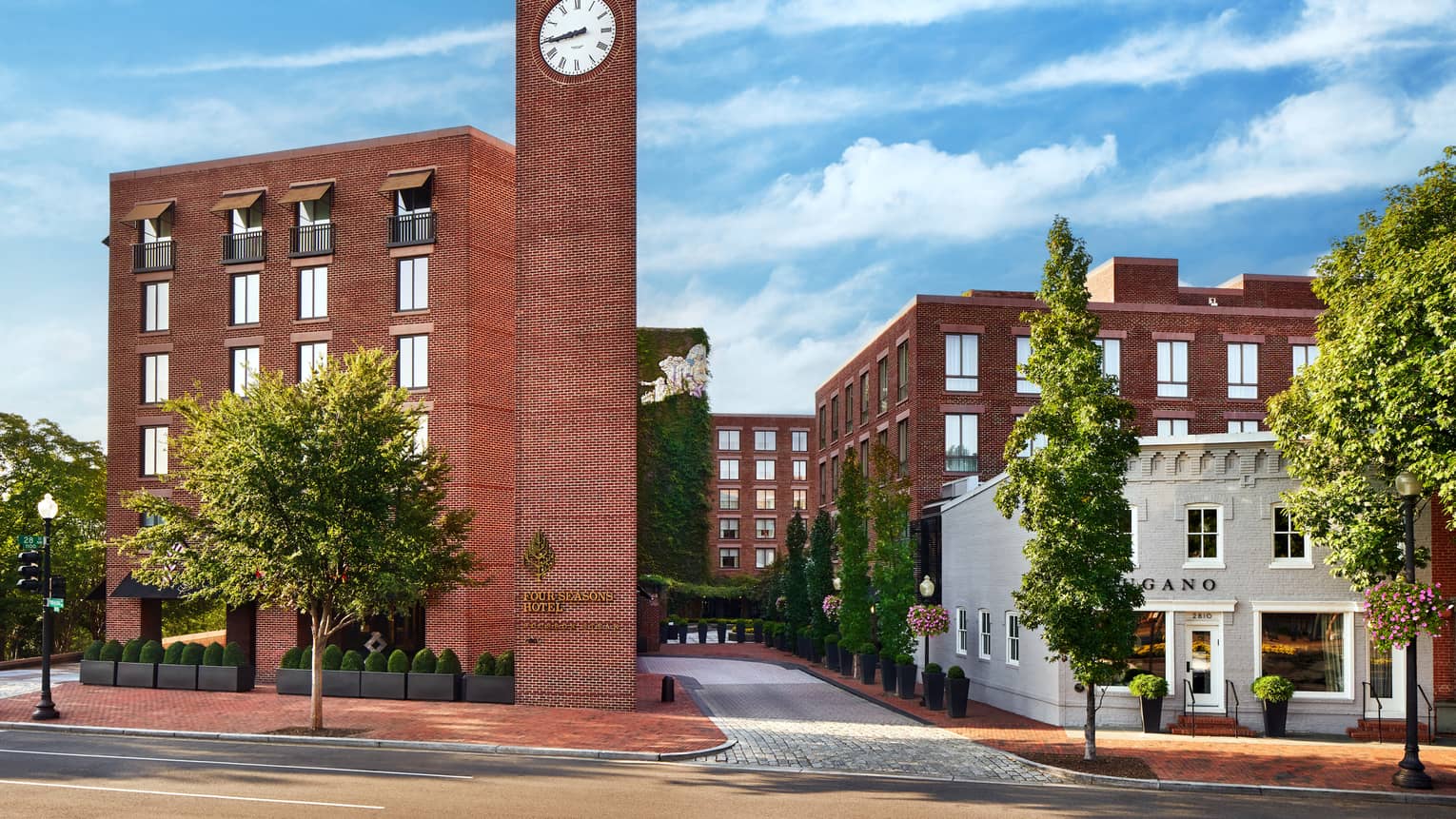 View of the brick buildings, a clock tower and clouds in the sky