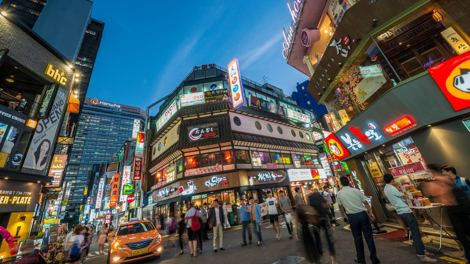 People gather under billboards, lights in Seoul city