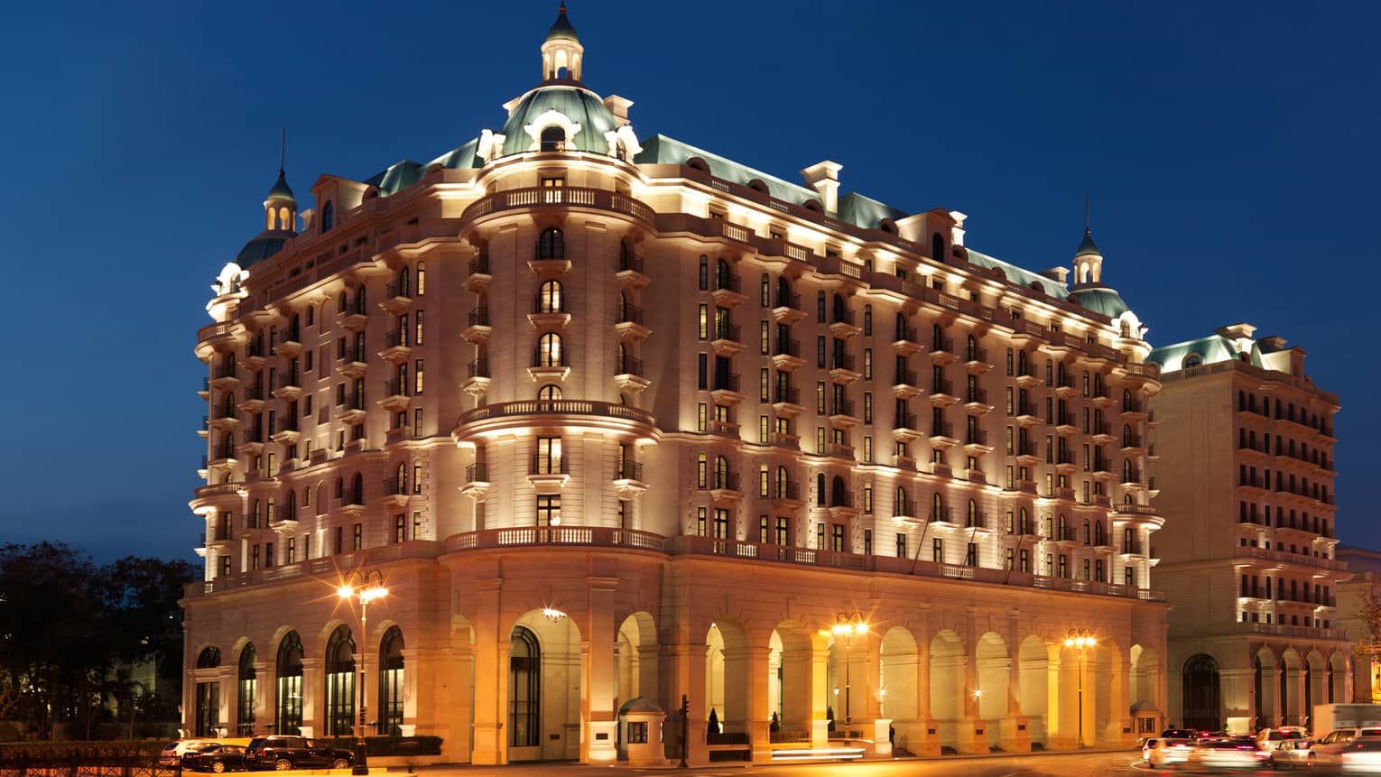 Night view of Baku Four Seasons Hotel Beaux-Arts-style building exterior with lights, illuminated roof