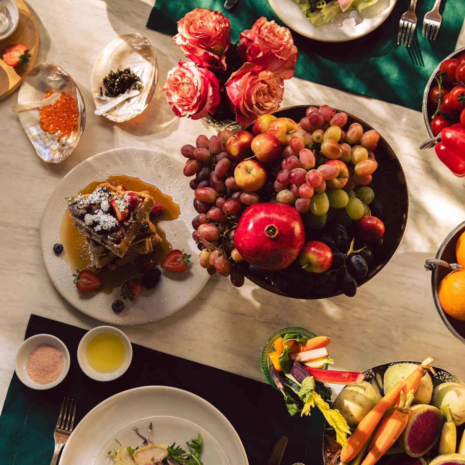 A dining table set with culinary dishes, including a fruit bowl and salad