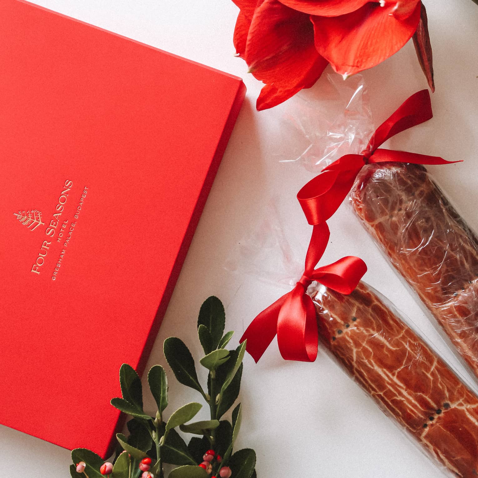 Red Four Seasons gift box, mistletoe, amaryllis and two wrapped Beigli with red bows