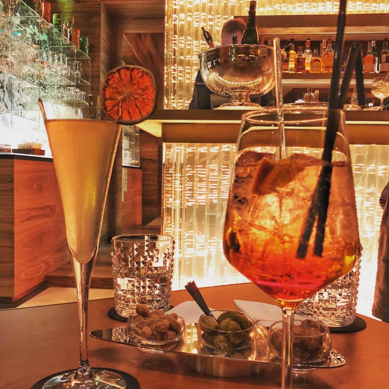 Amber cocktails, orange garnish by crystal glasses on lounge table