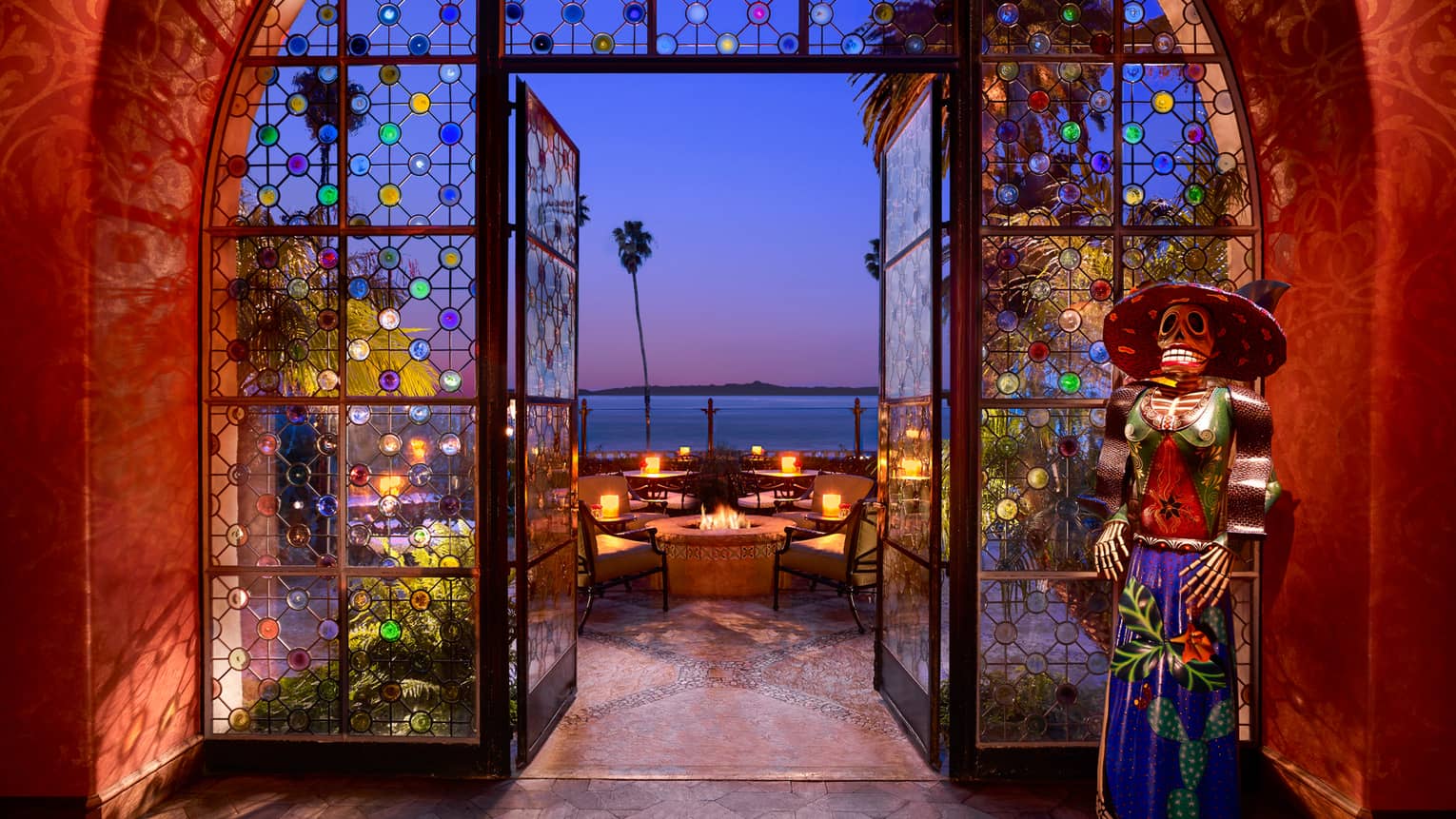 Colourful stained glass circles on window archway, door to Ty Lounge balcony, Day of the Dead statue