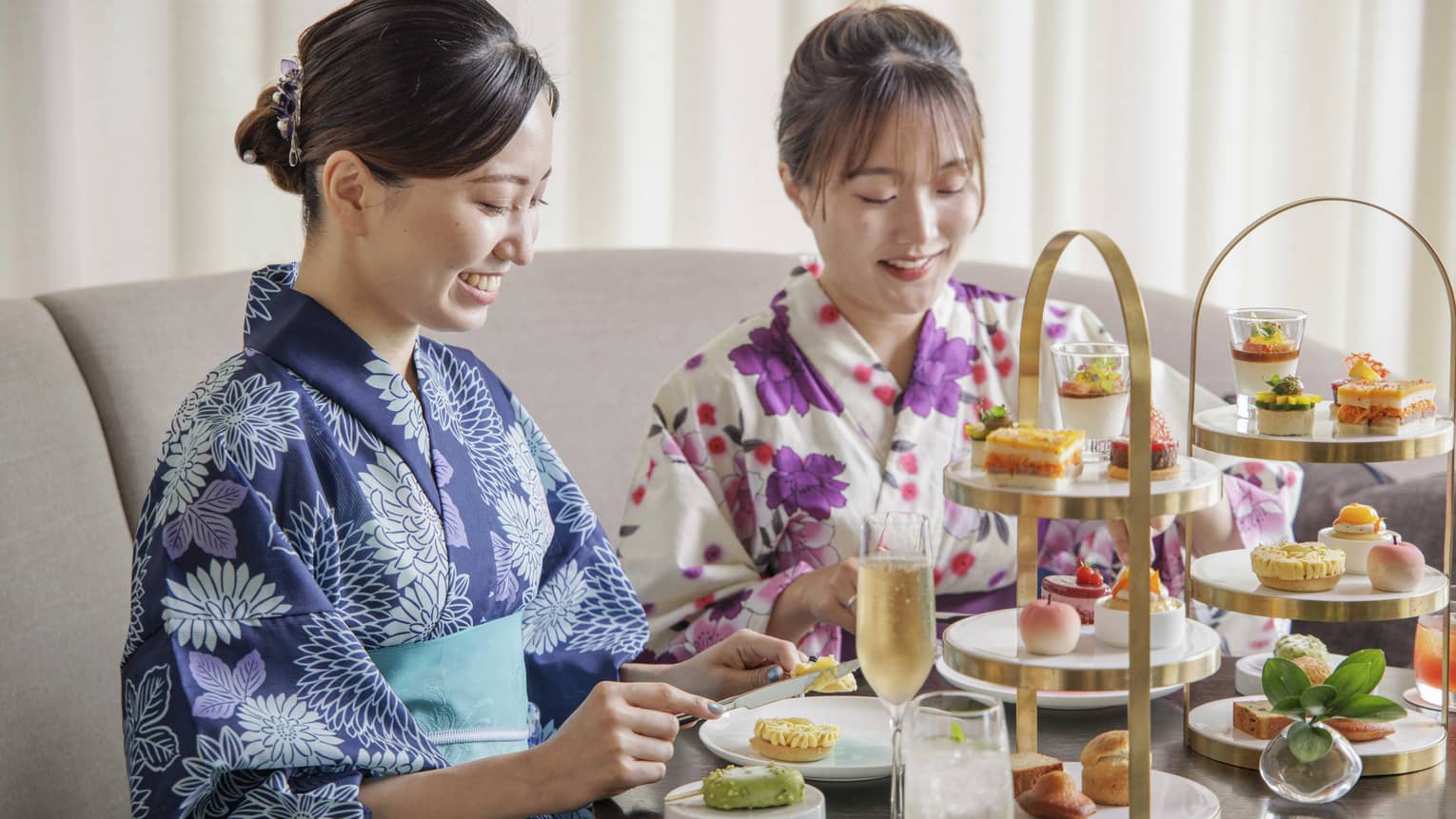 Two guests dressed in yukatas enjoy an afternoon tea spread