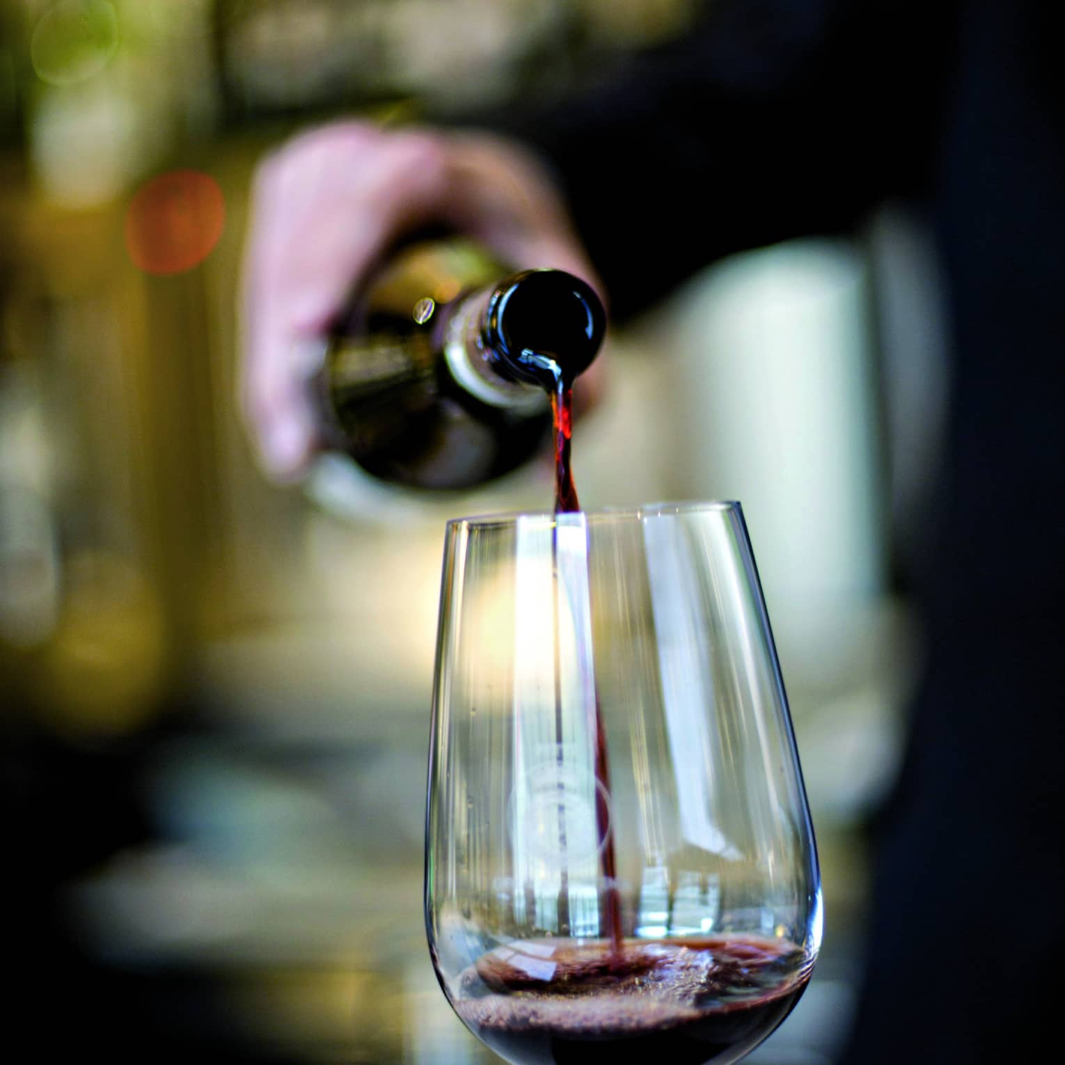 Red wine being poured into a glass.