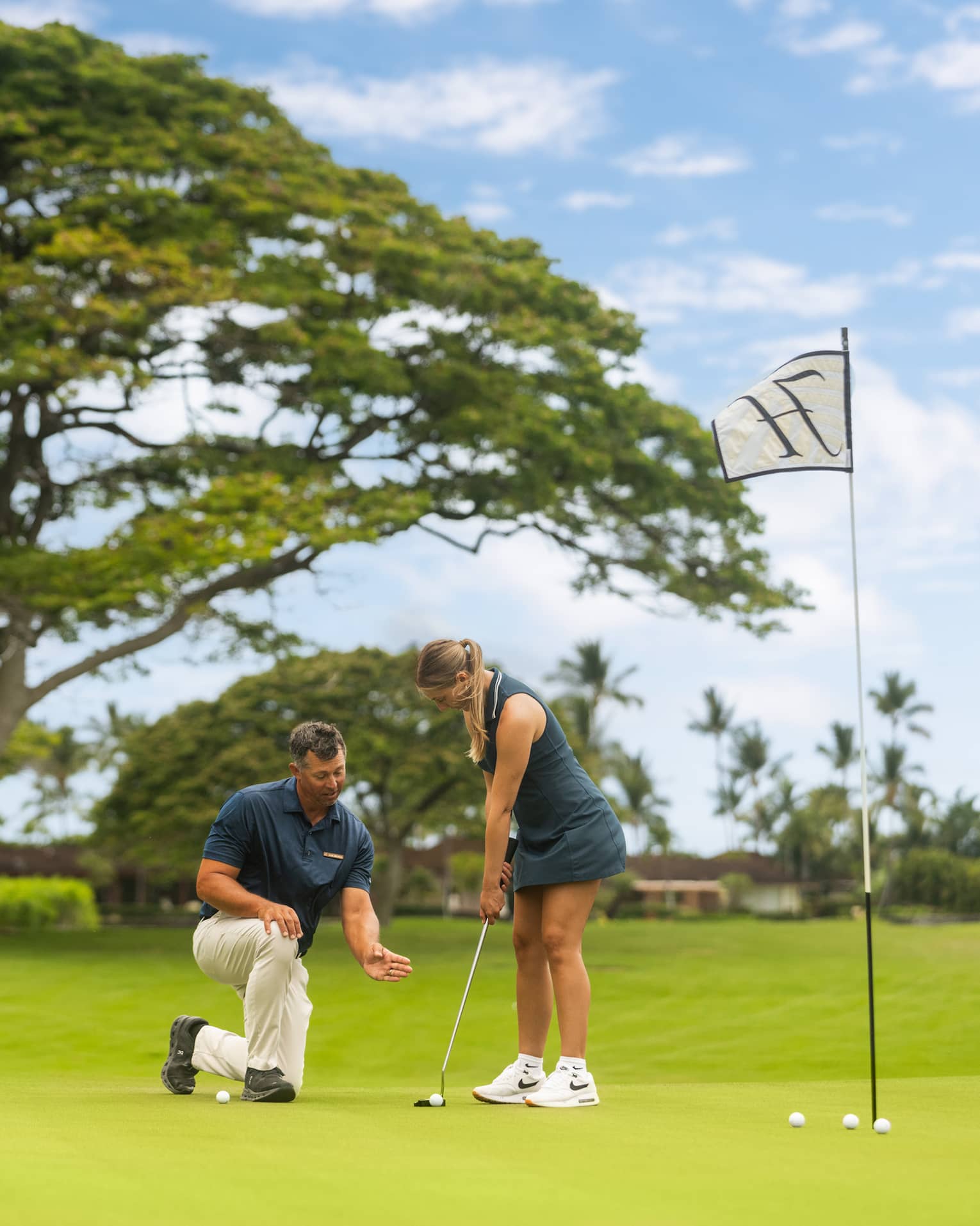 A woman practices her putting during a golf lesson.
