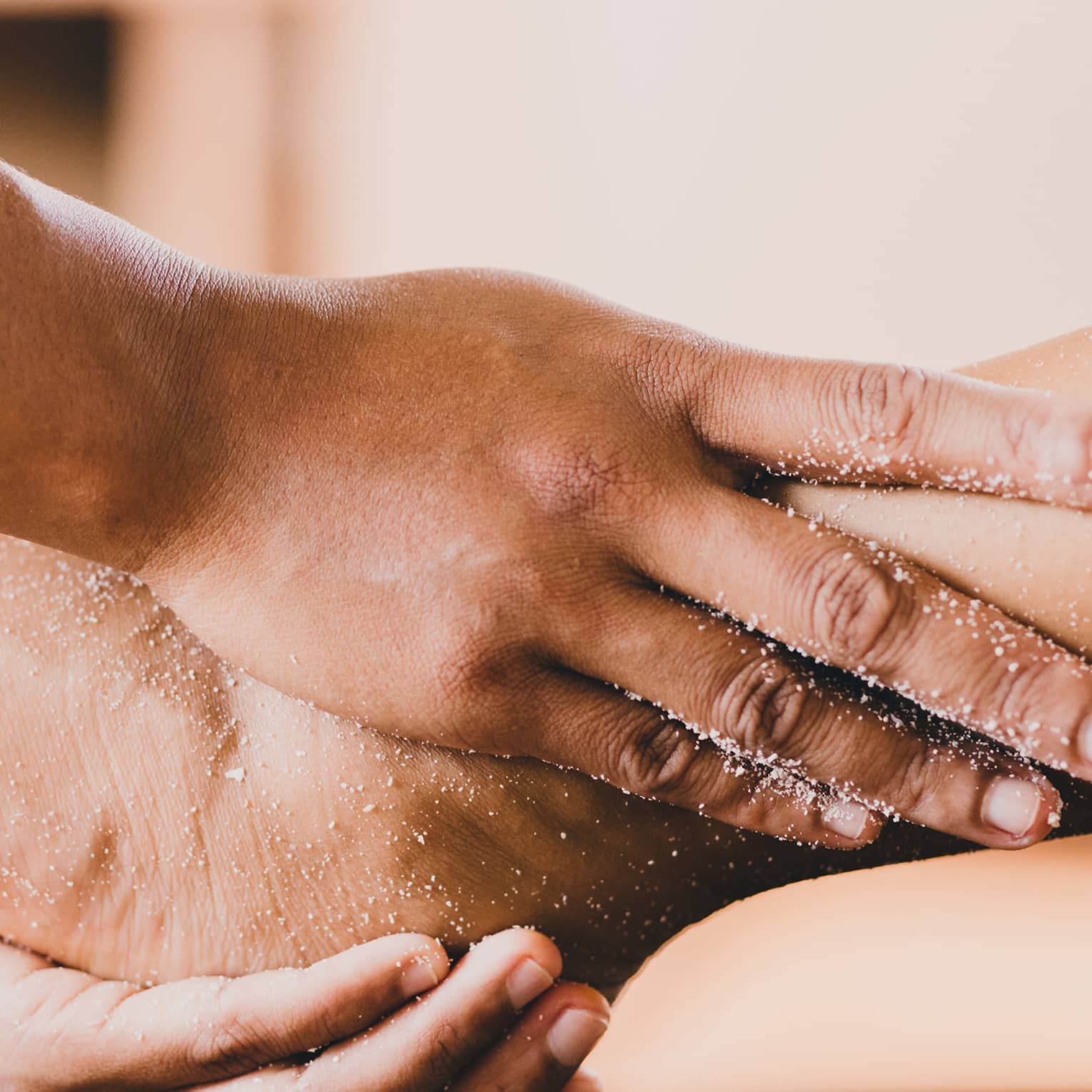Hands hold a person's foot and ankle in a spa