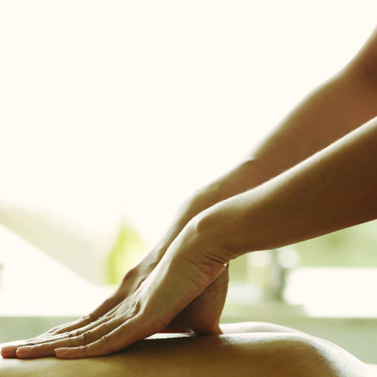 Close-up of a person receiving a relaxing back massage in a spa setting.