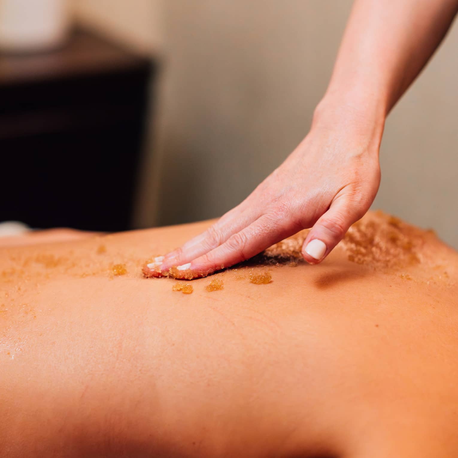 Scrub being put on back during massage.