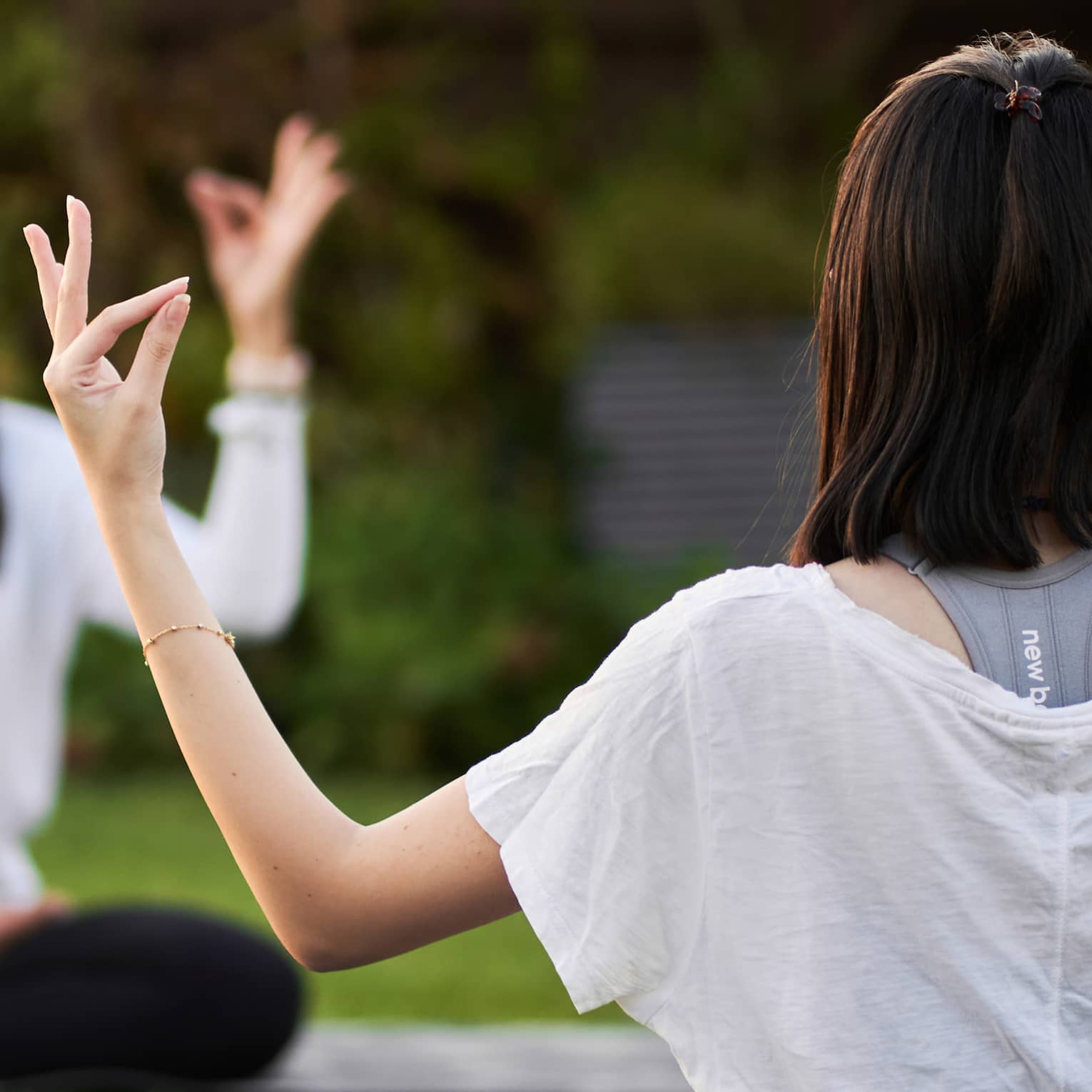 Guests doing yoga outdoors on yoga mats with trees in the background