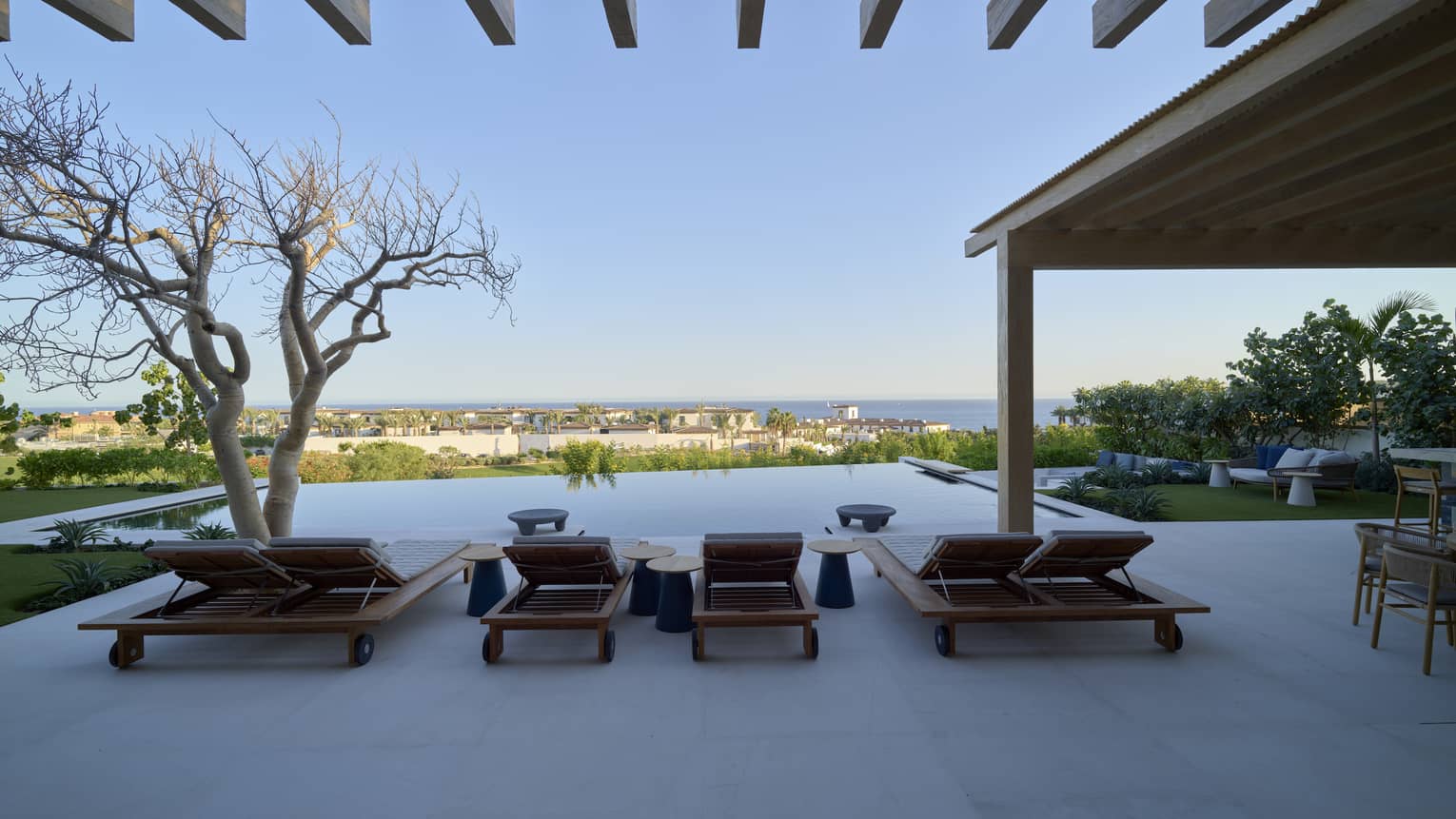 Sea-view pool terrace with sun loungers and covered dining area
