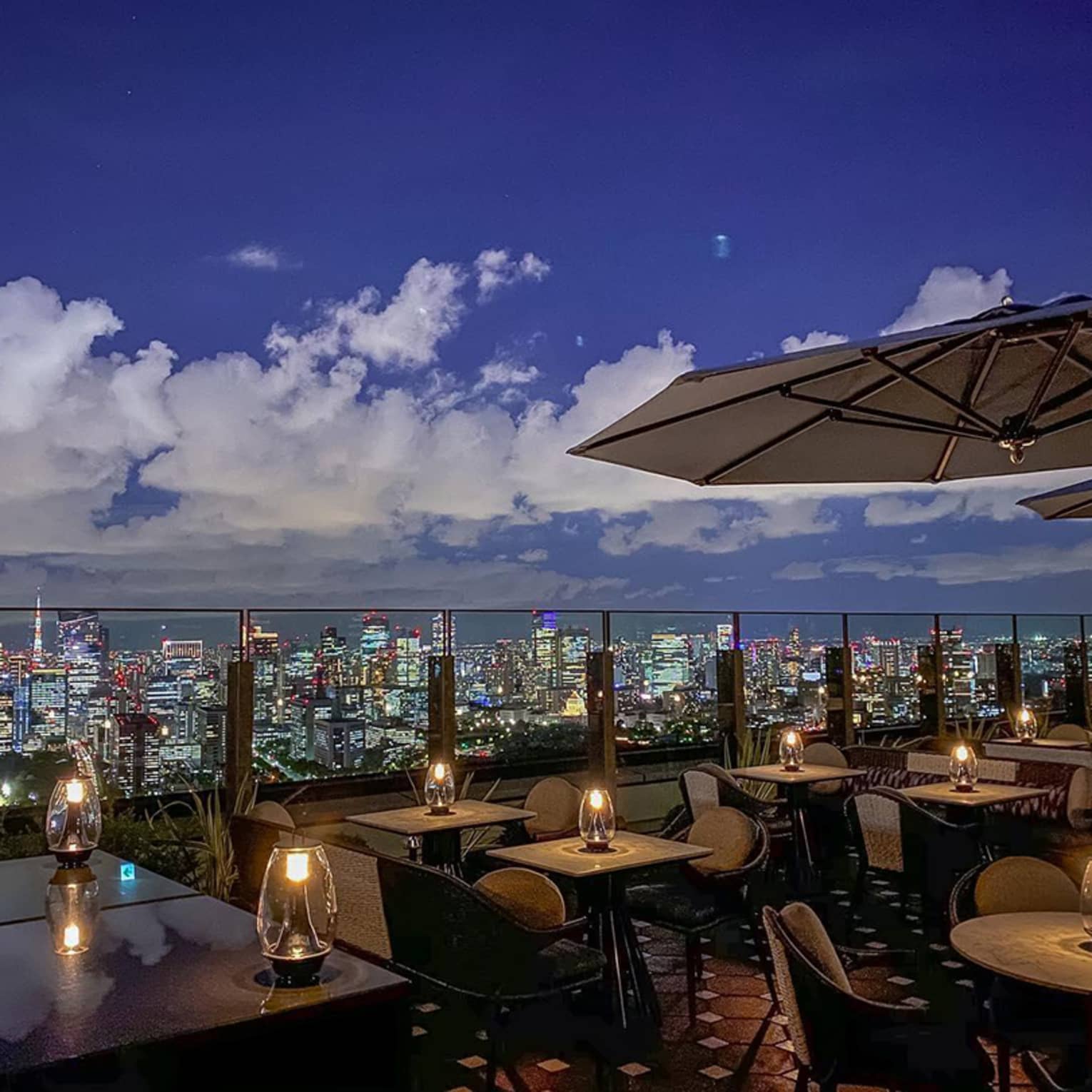 Rooftop patio at night with glowing candles in lanterns on tables