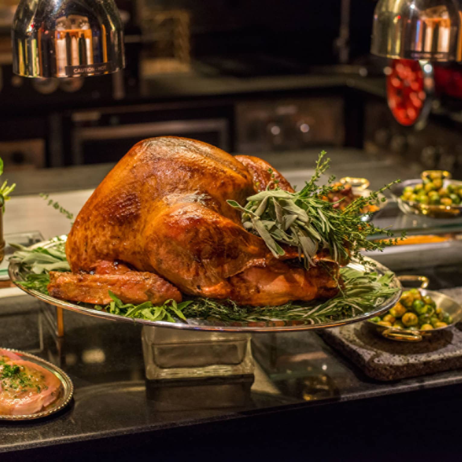 A variety of thanksgiving style good including turkey, sweet potatoes, vegetables, and more.