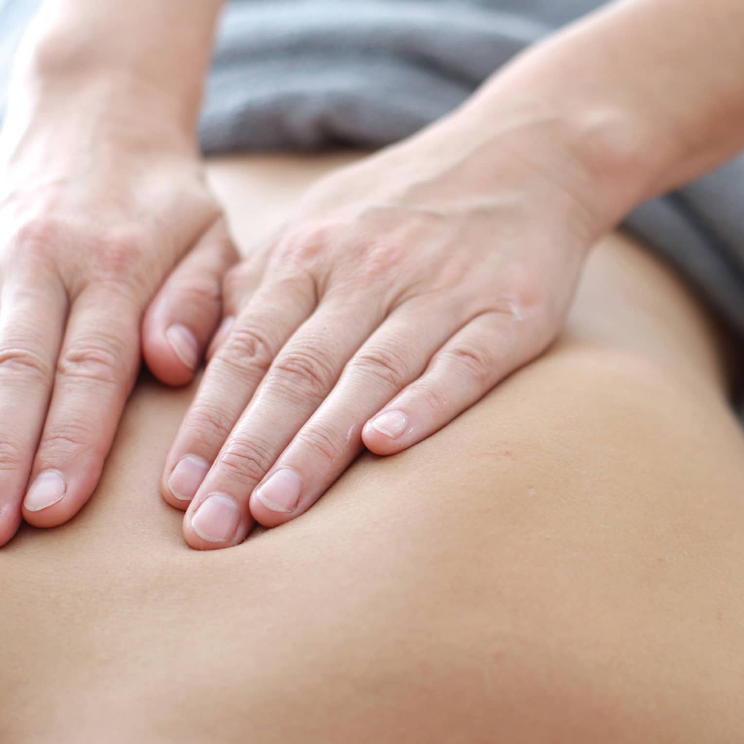 Hands massaging bare shoulders, back