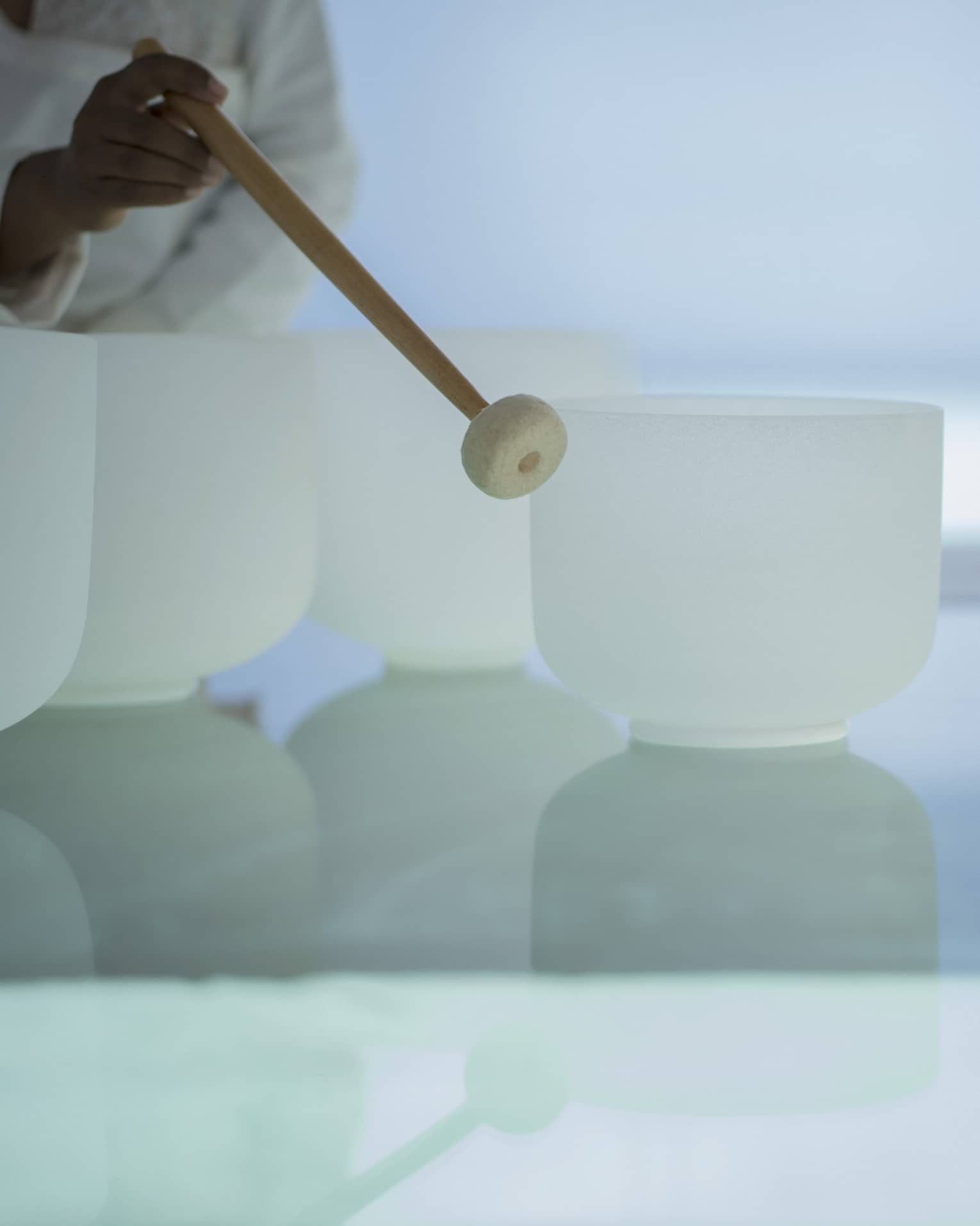 Woman plays singing crystal bowls at the Spa