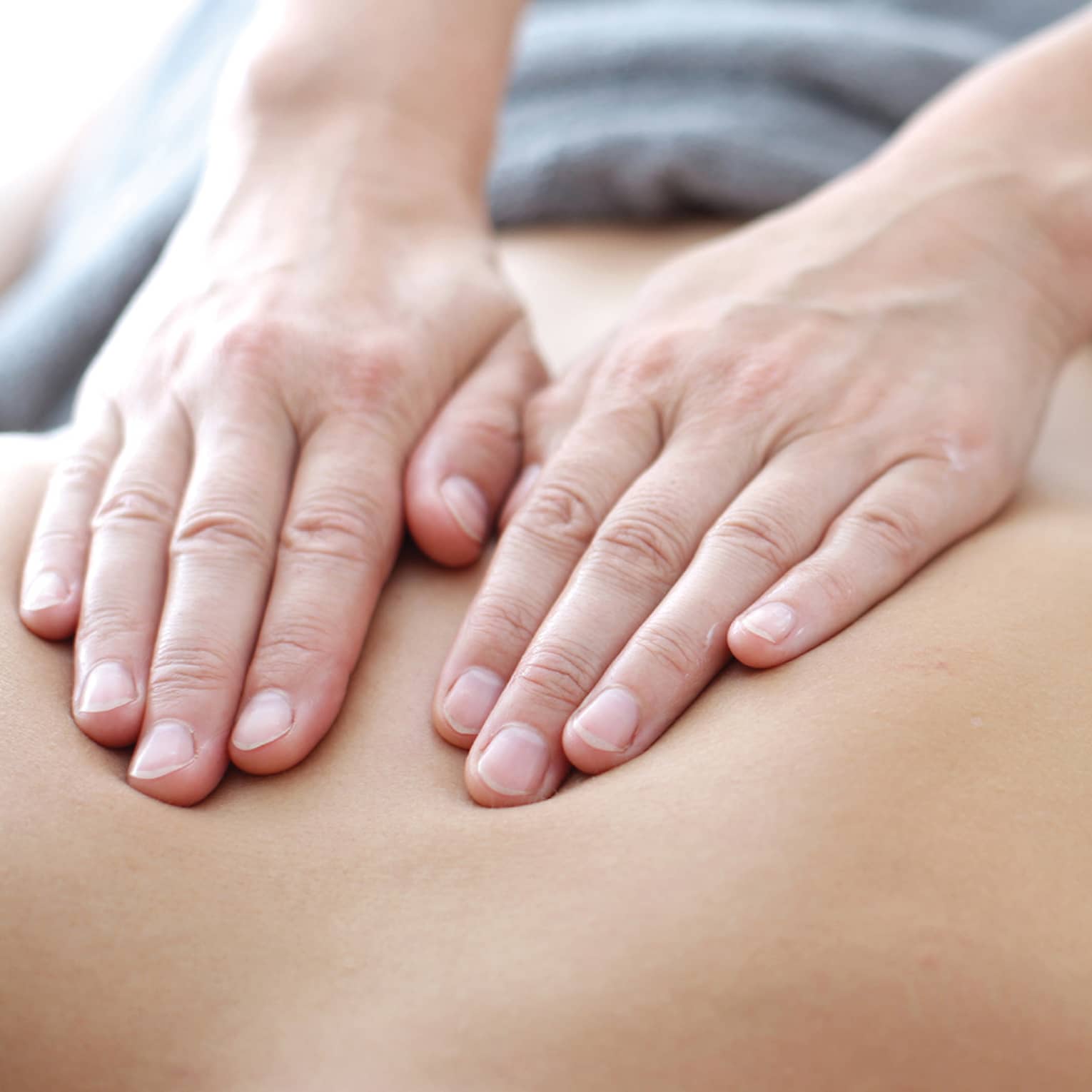Hands massaging bare shoulders, back