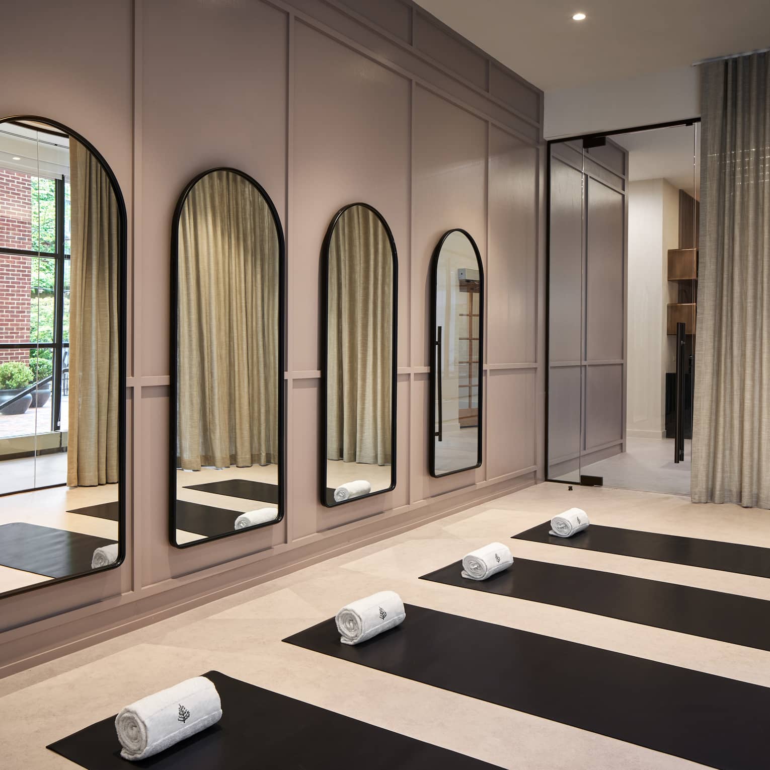 Yoga mats in a yoga studio with mirrors on the wall.