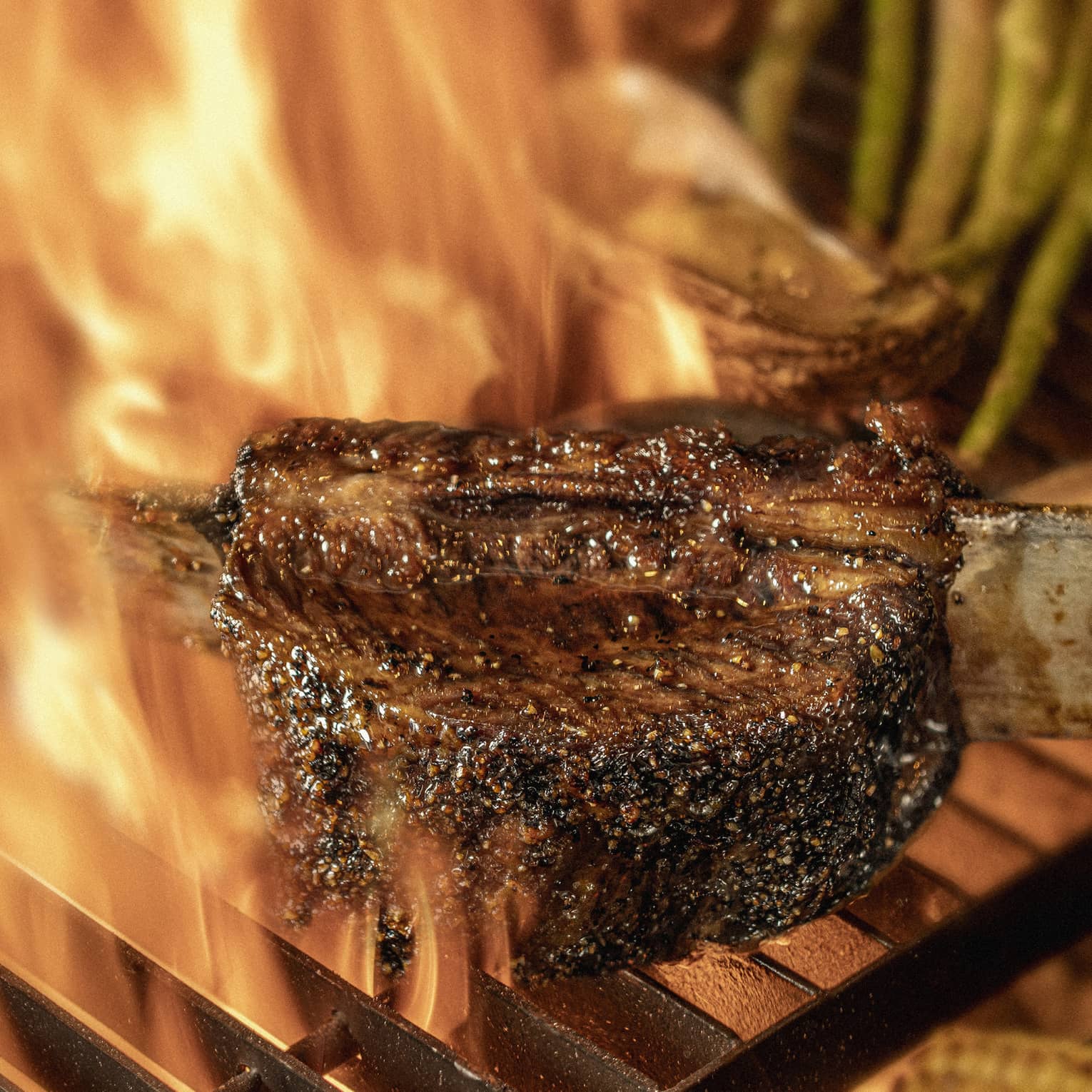 Close-up of chargrilled steak, asparagus and corn on grill grates