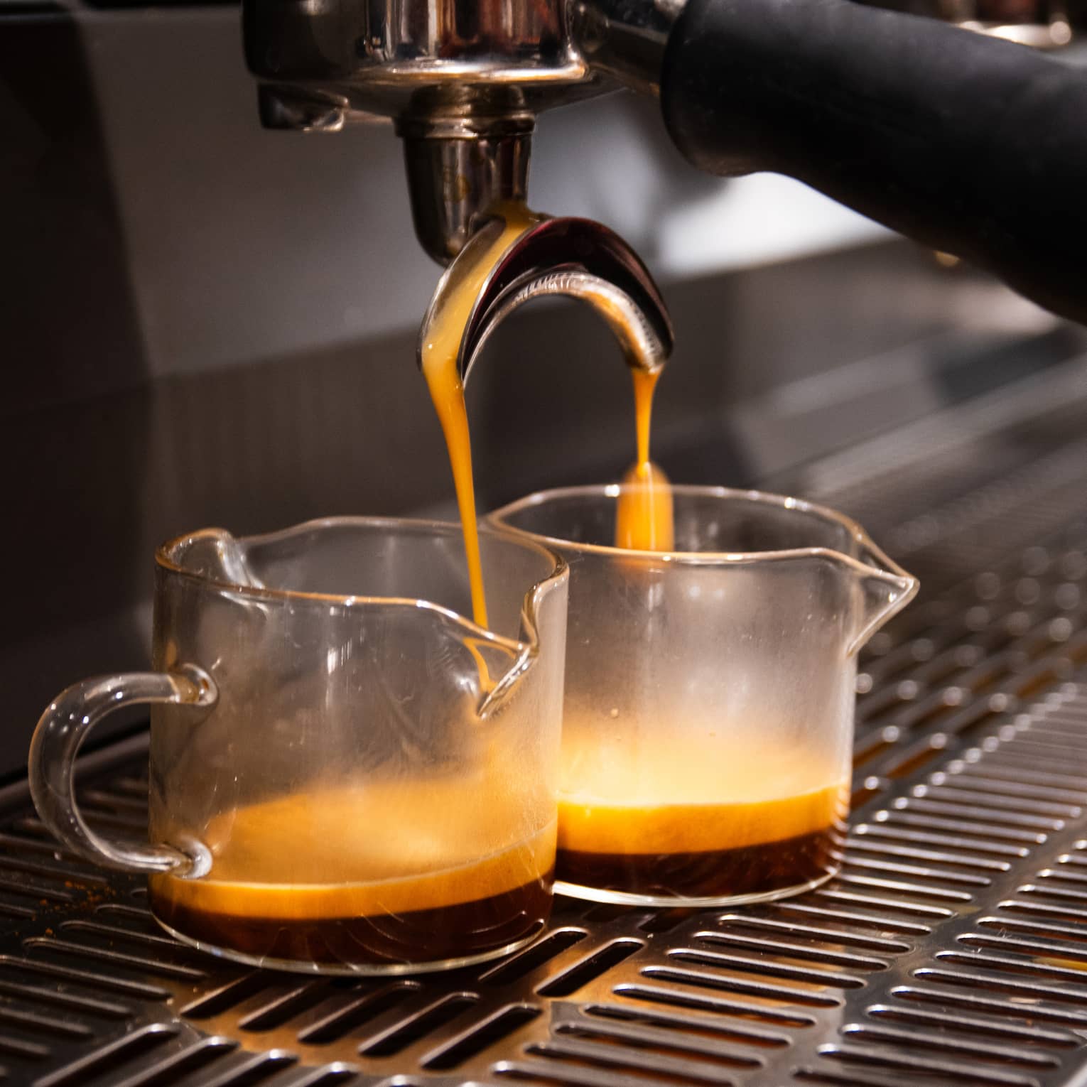 Two cups of coffee being brewed
