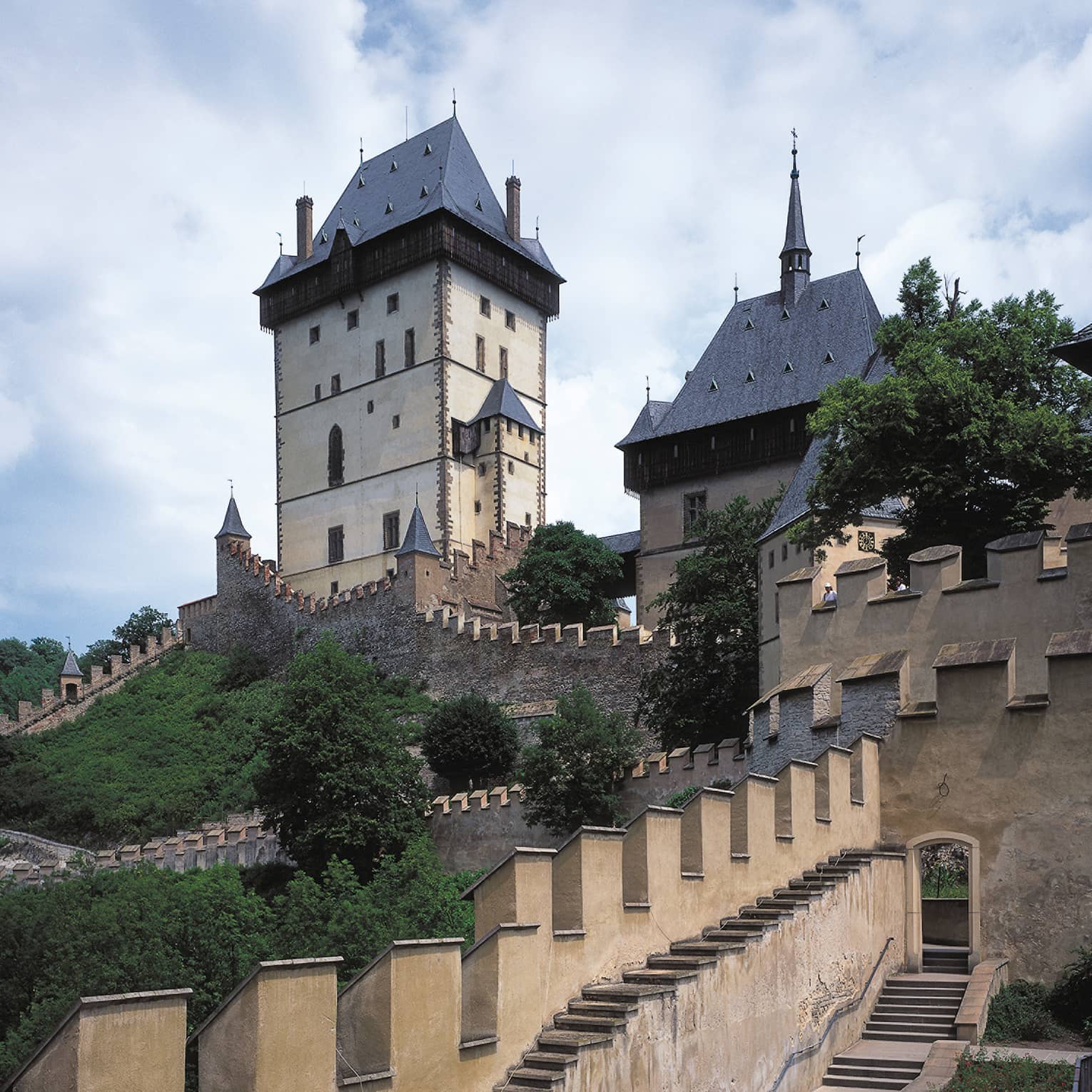 Looking up at historic Prague Karlstejn Castle towers, castle walls on sunny day