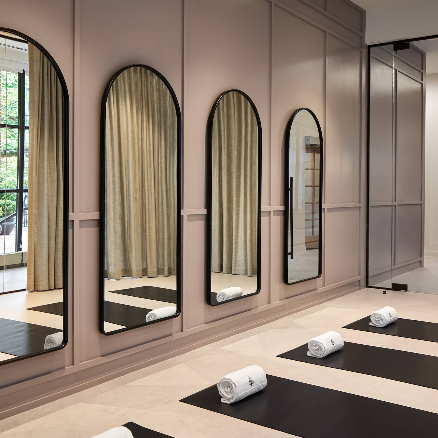 Yoga mats in a yoga studio with mirrors on the wall.