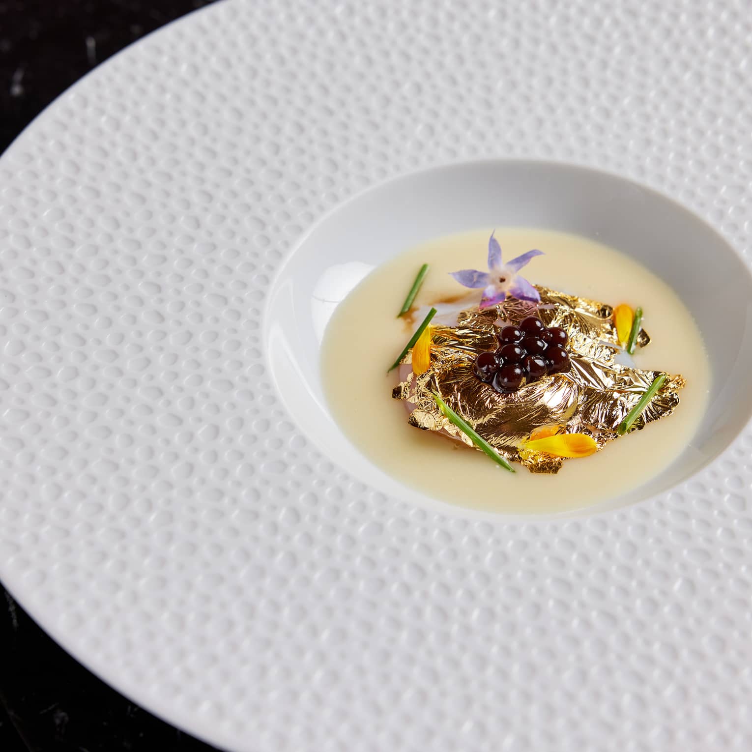 Food on a white plate on a dark table.