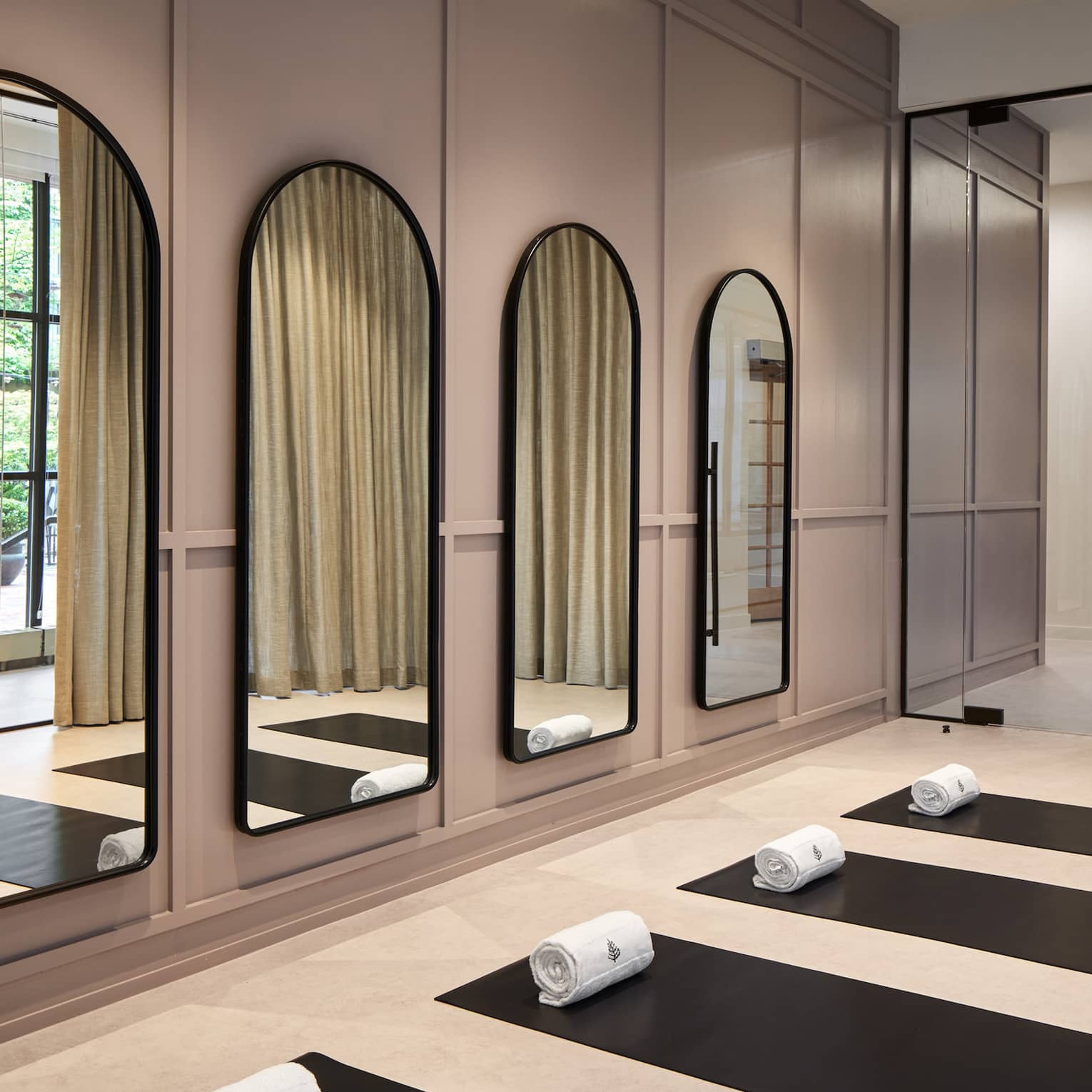 Yoga mats in a yoga studio with mirrors on the wall.