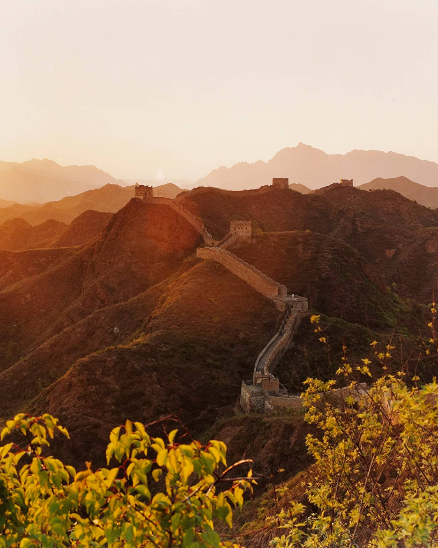 Sunset over mountain, trees with Great Wall of China along side