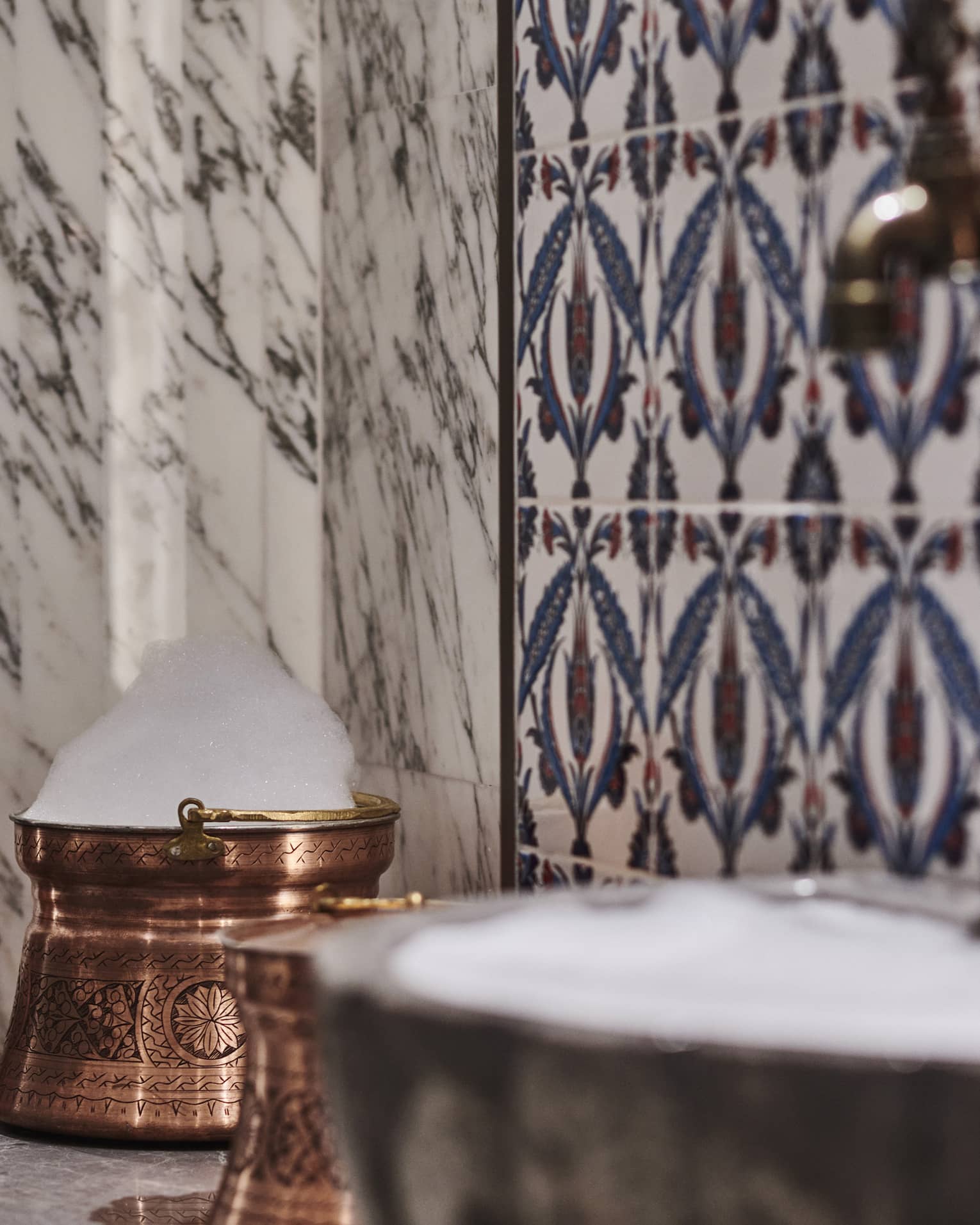 Kuma Spa tiles and marble walls by copper sink