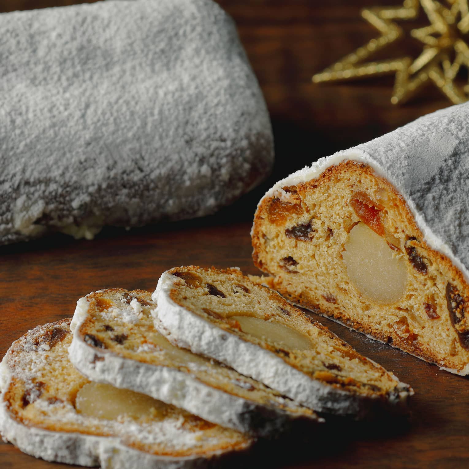 Stollen, sliced on a wooden table with festive decor