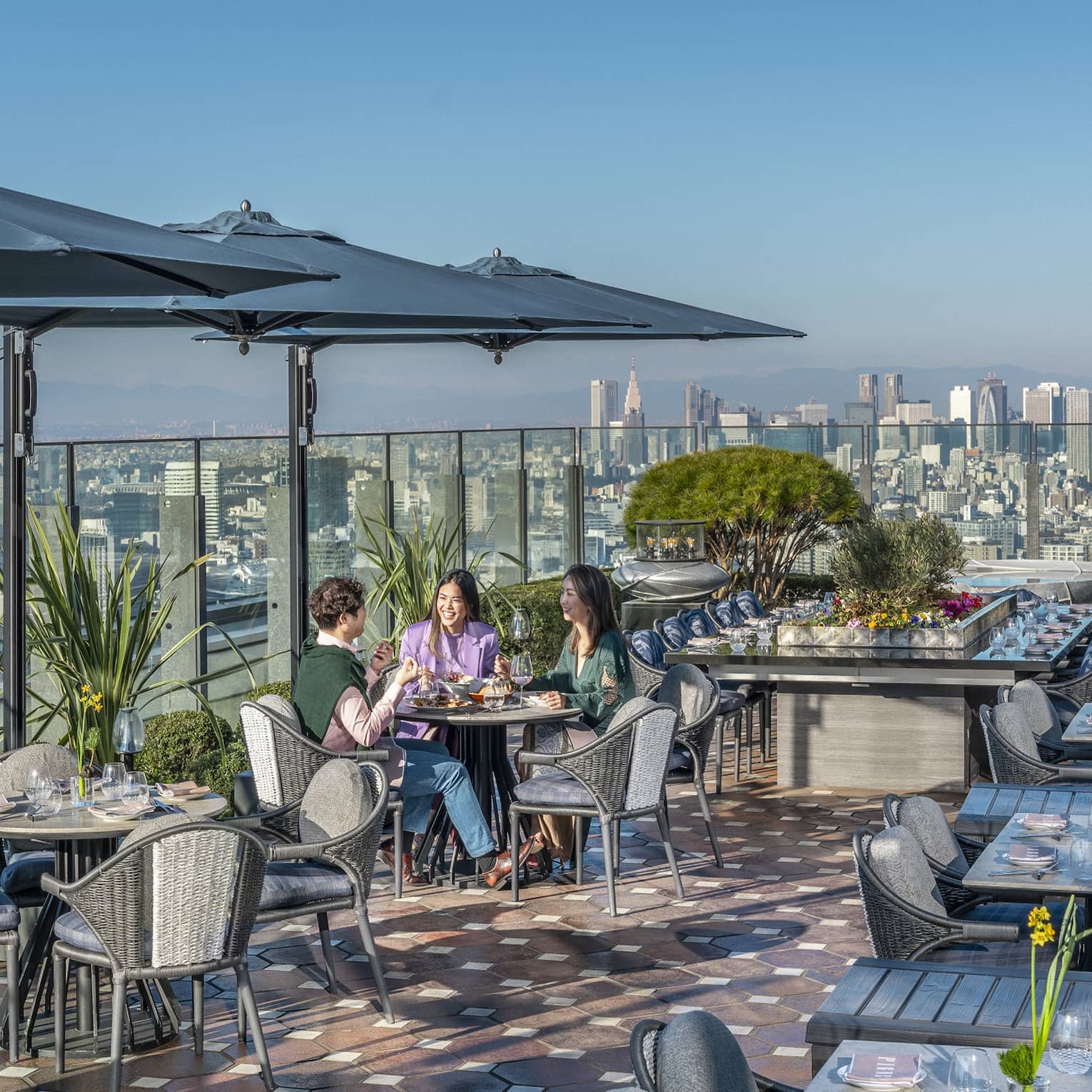 Group of three friends enjoy a meal on PIGNETO's open-air terrace