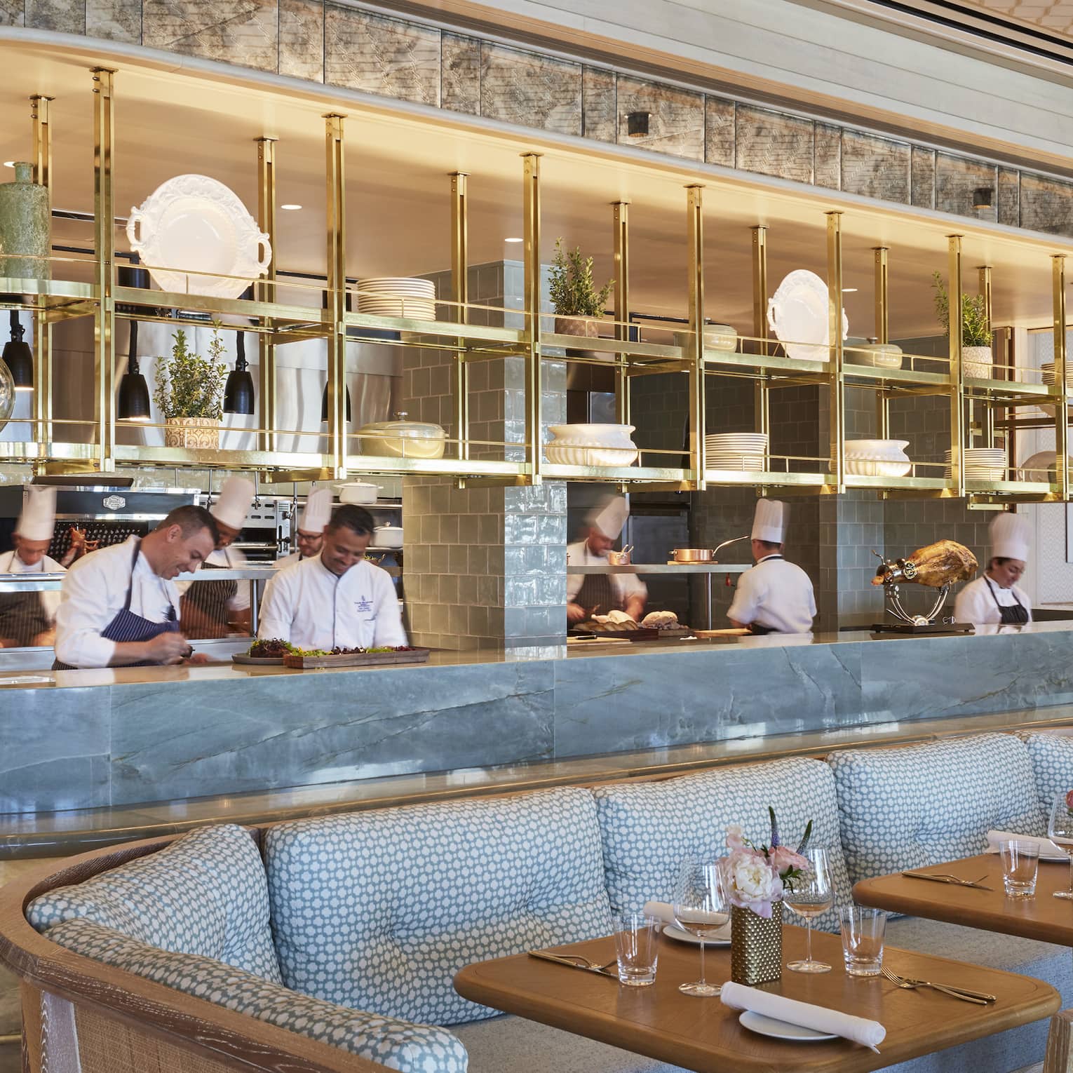 Staff members behind Flories curved blue marble bar, blue banquette seating