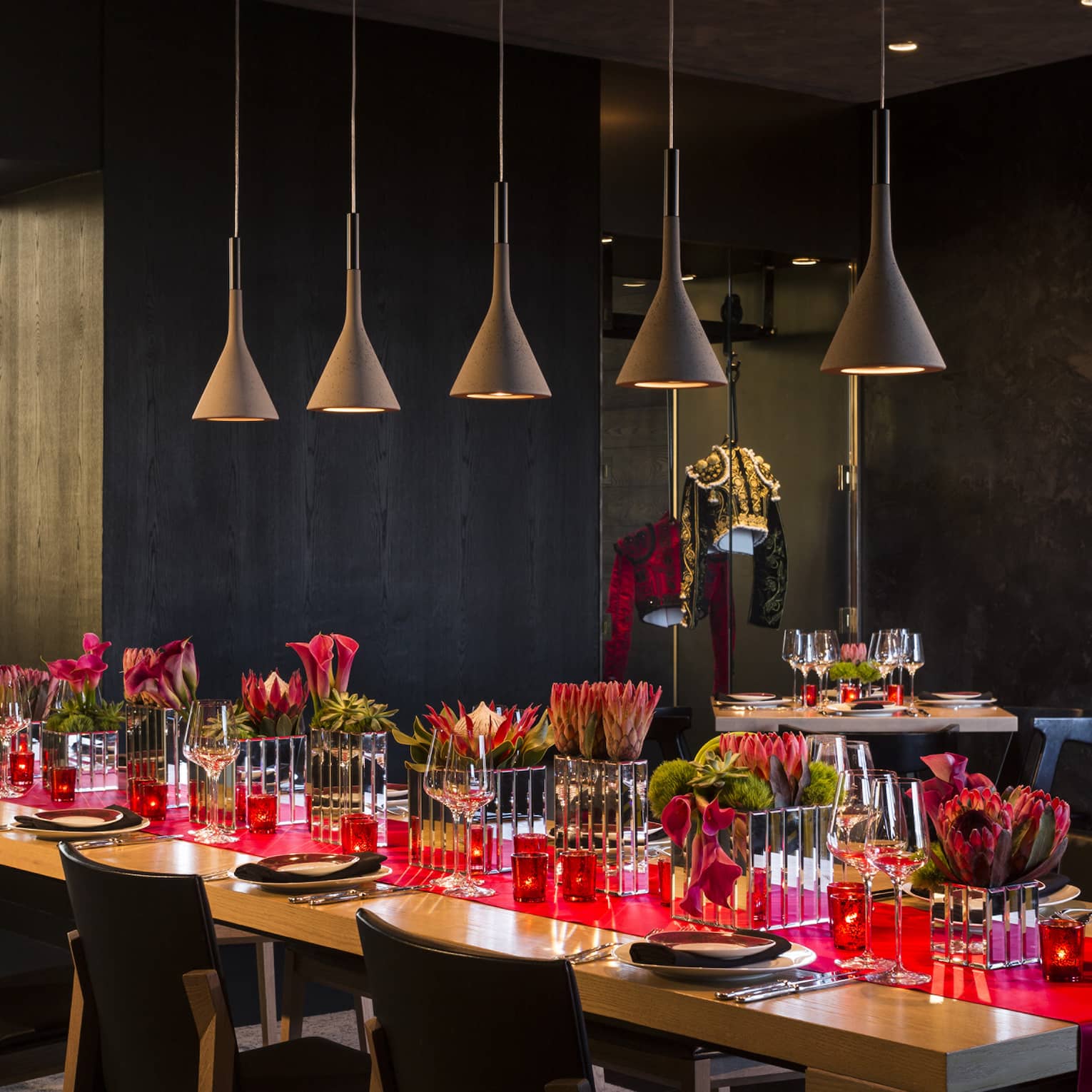 Long table with red runner under row of lamps in San Sebastian private dining room