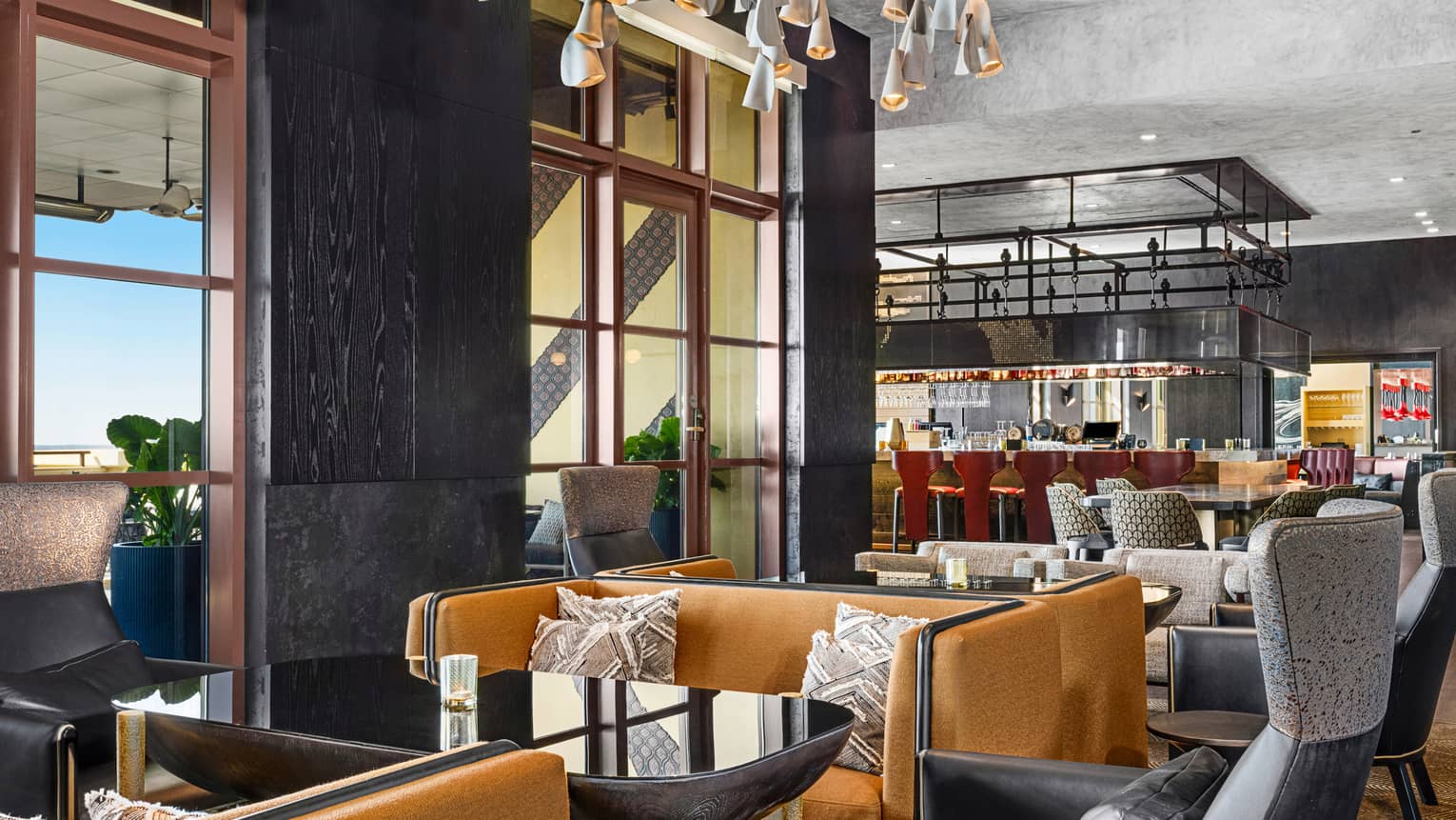 Capa restaurant with orange coloured couches and black chairs.