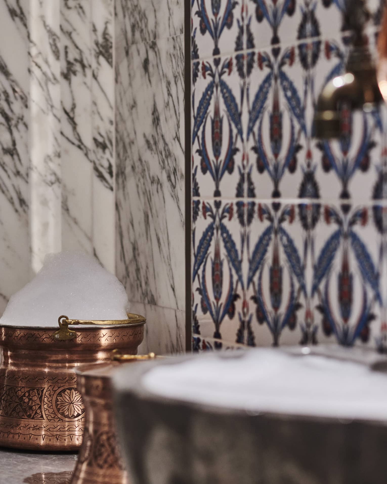 Kuma Spa tiles and marble walls by copper sink