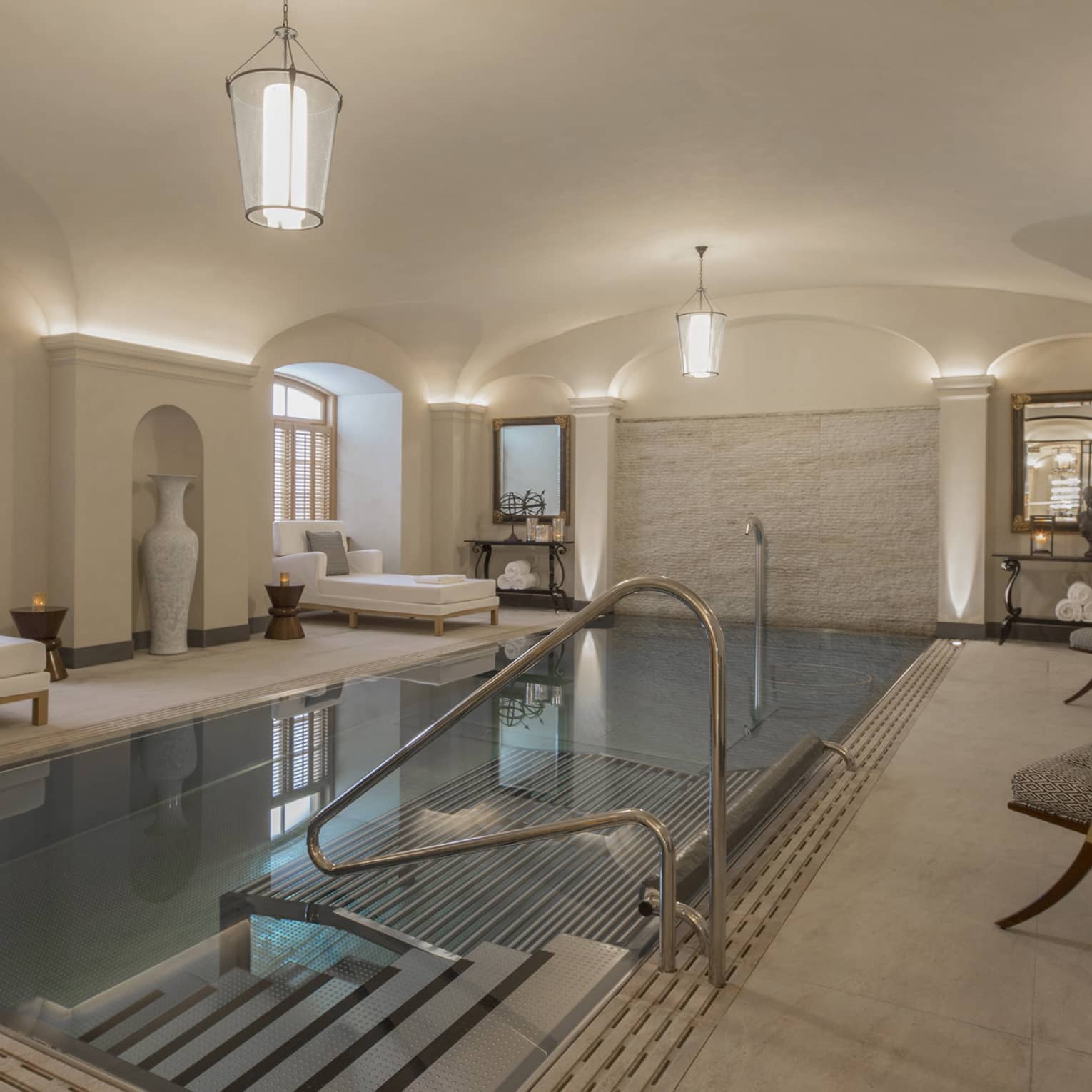AVA Spa vitality pool flanked by white lounge chairs under domed ceiling