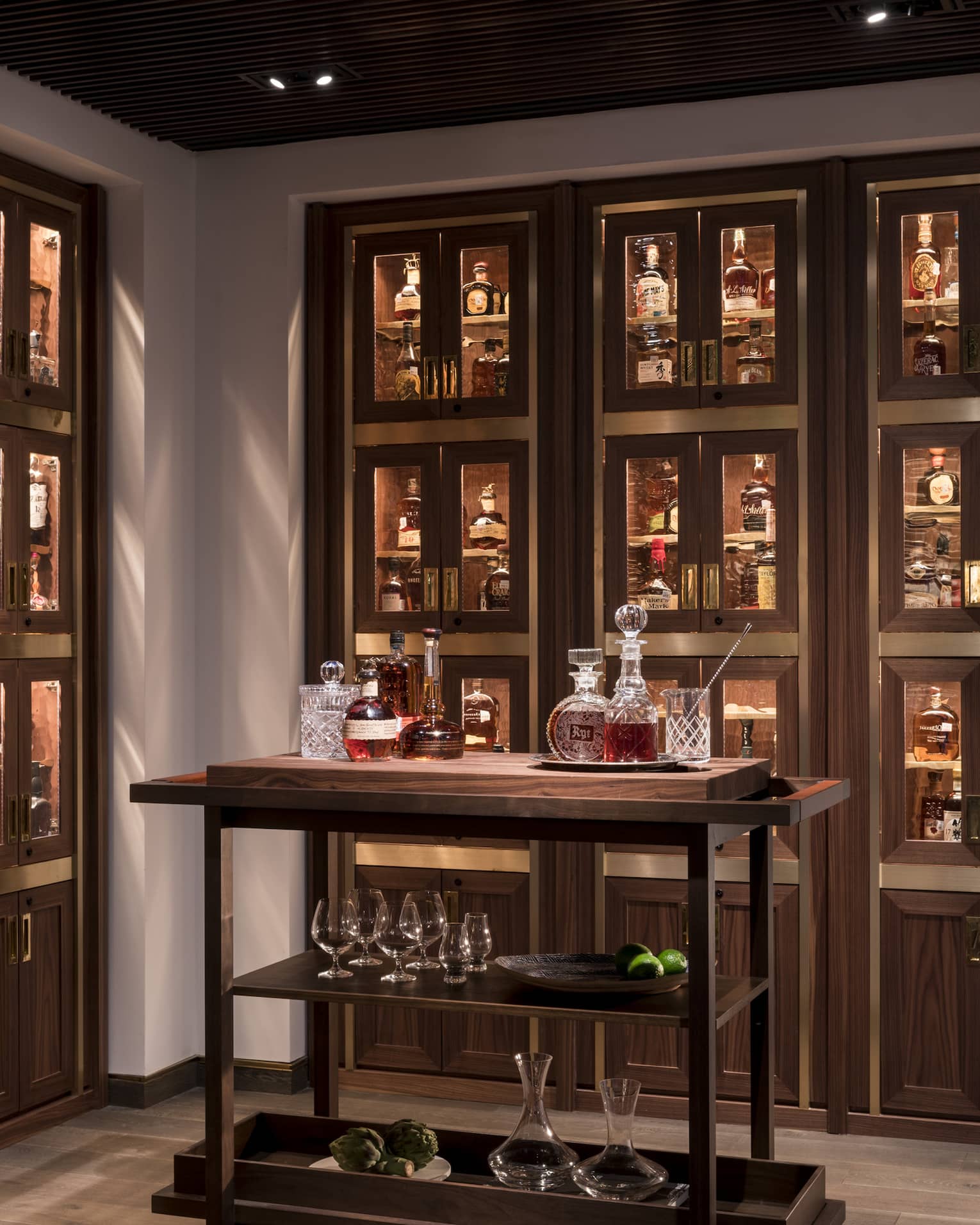 Various whiskey, bourbon, crystal bottles on bar