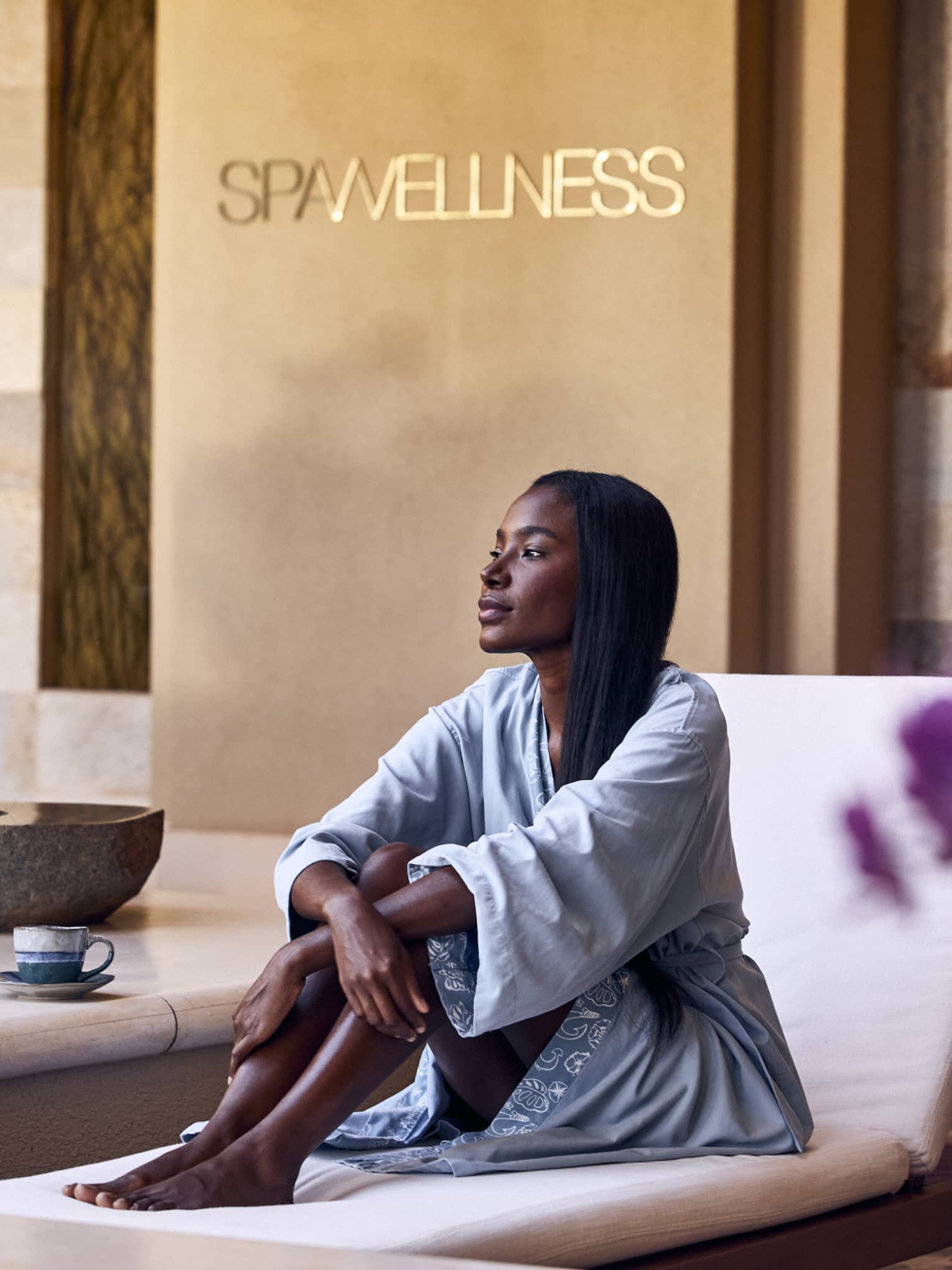 A woman sitting on a lounge chair in a spa.