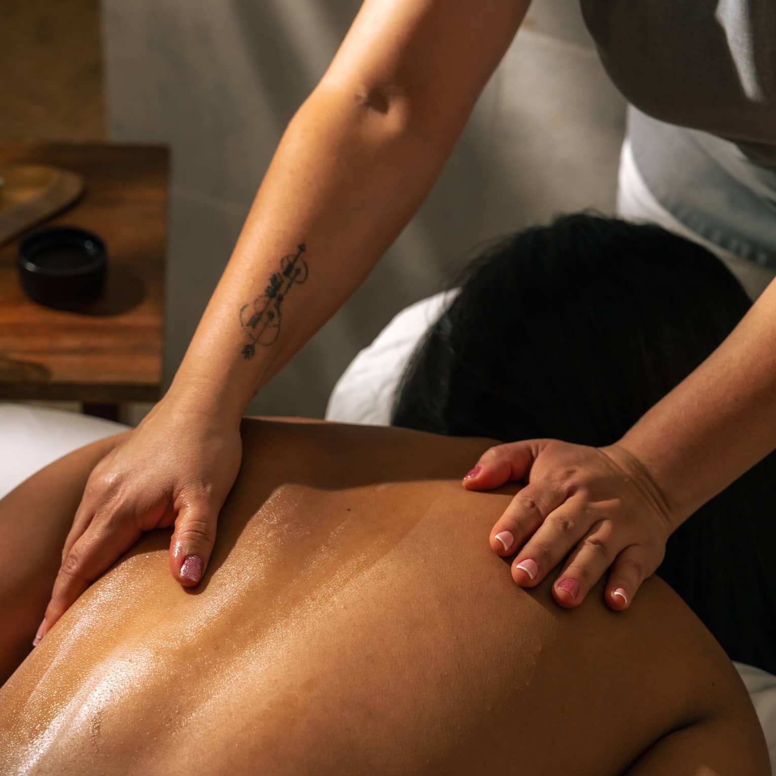 Pair of hands massages a bare back