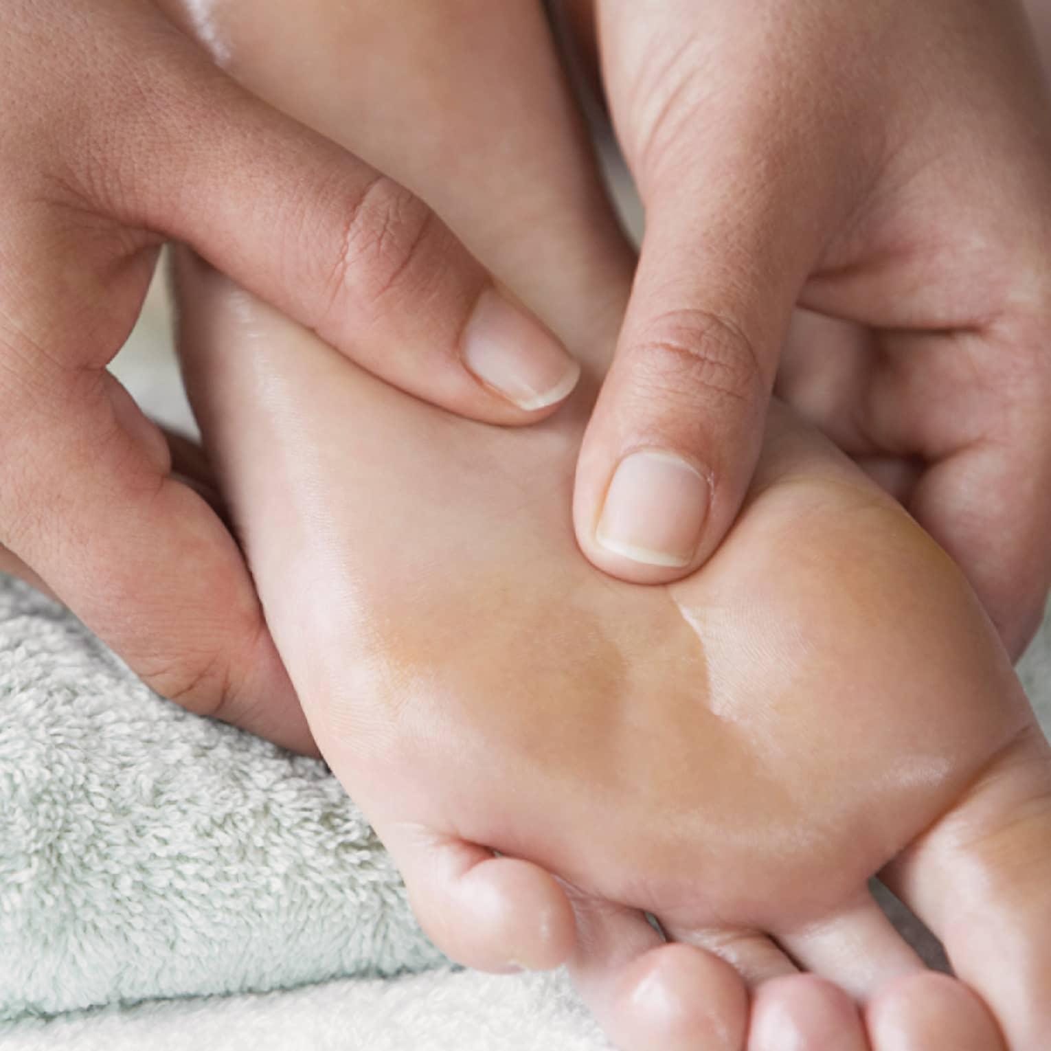 Close-up of hands massaging pressure points on feet