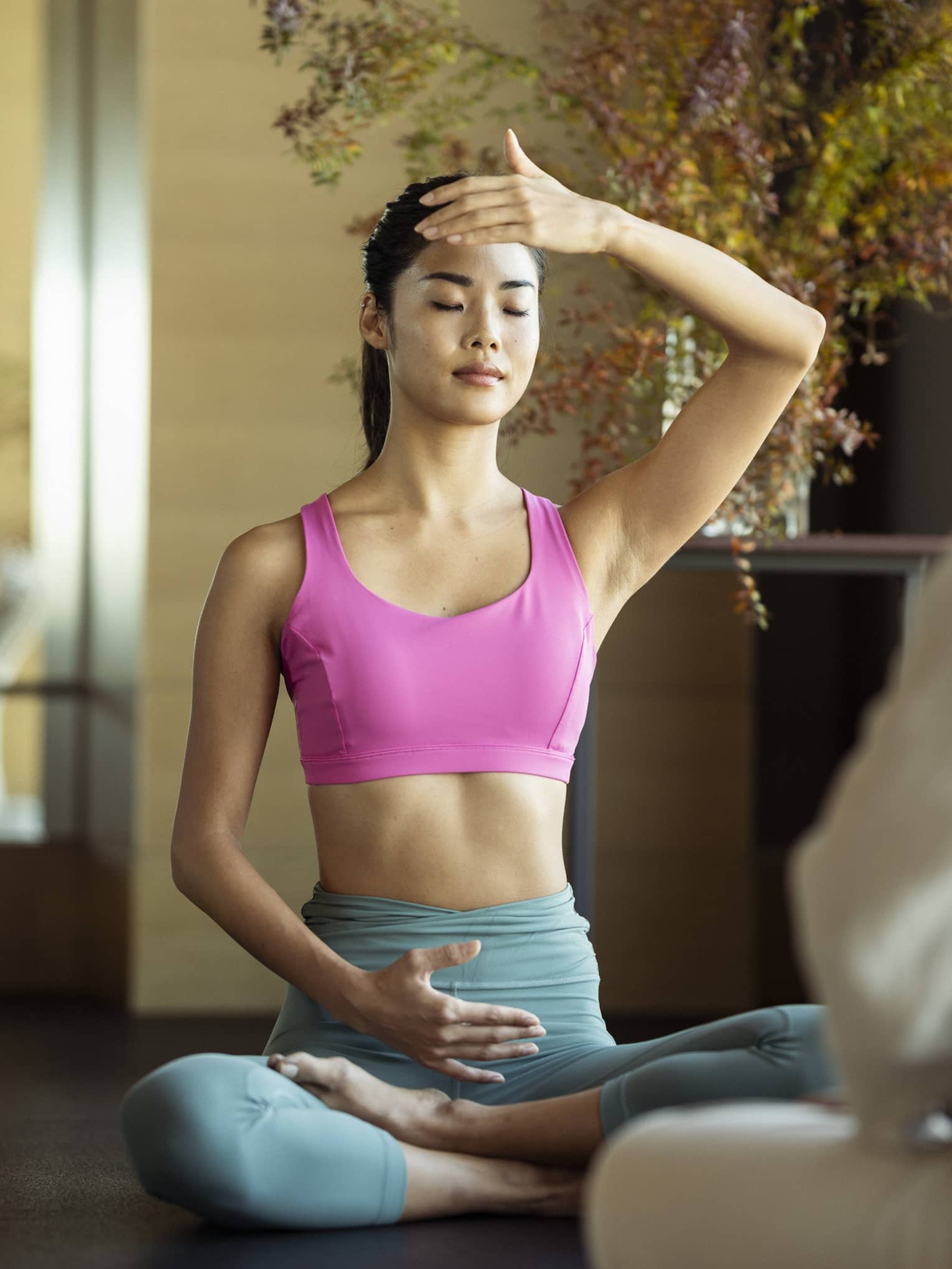 Woman sits cross-legged as she practices yoga and breathing exercises