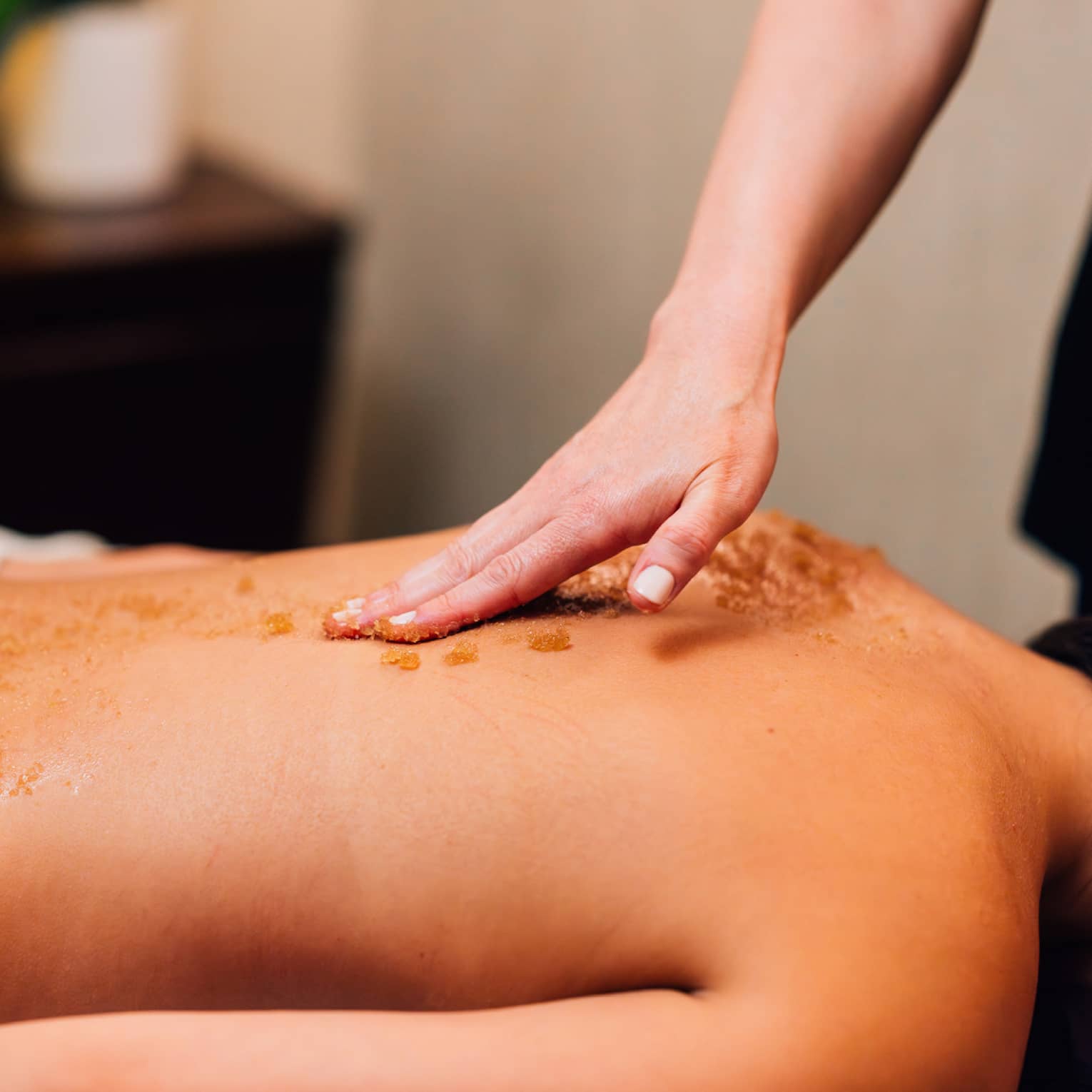 Scrub being put on back during massage.
