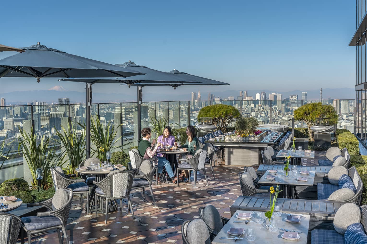Group of three friends enjoy a meal on PIGNETO's open-air terrace