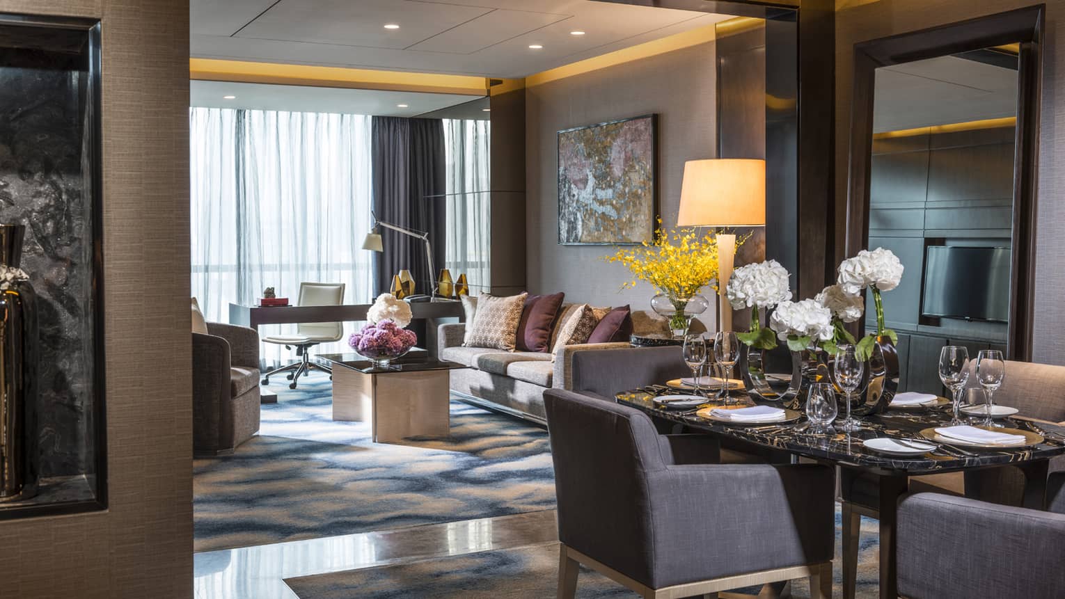 Deluxe Suite dining table with white flowers, living room, desk at window, art