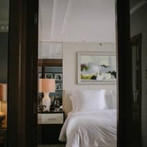 ,A guest room bed surrounded by modern decor and art