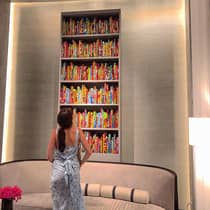 A girl glances up at a floor to ceiling bookshelf