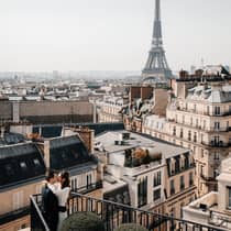 Couple embracing on Paris Hotel terrace with Eiffel Tower view