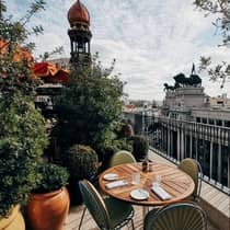 An outdoor dining table on a terrace with a view of Madrid