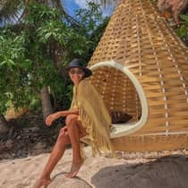 A woman enjoying a serene moment by the beach, on an outdoor wooden swing at Punta Mita