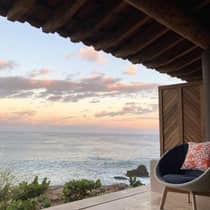 Oceanfront view from an outdoor terrace at Four Seasons Resort, featuring a comfortable chair
